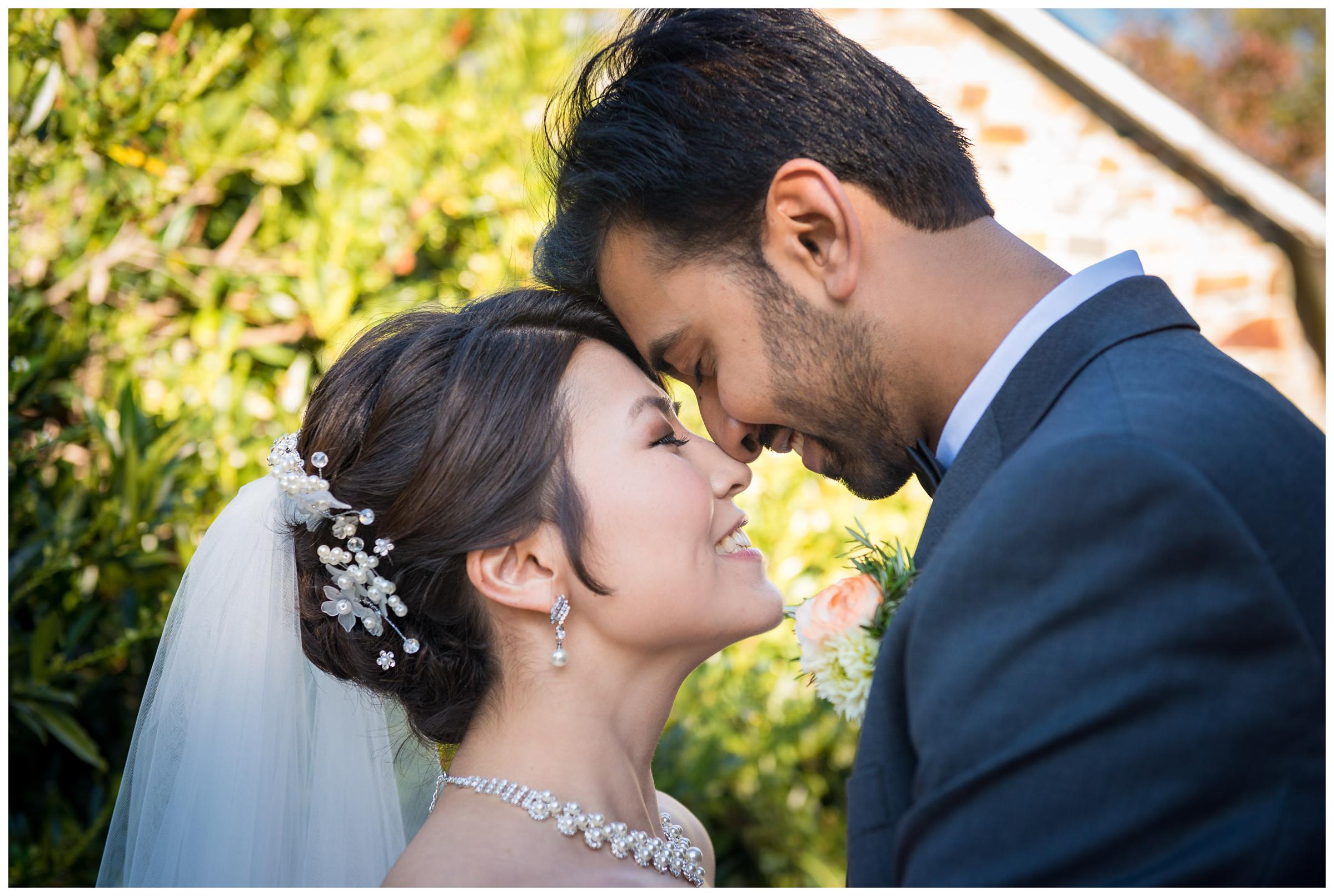 Portrait of bride and groom near stone ruins at rustic wedding.