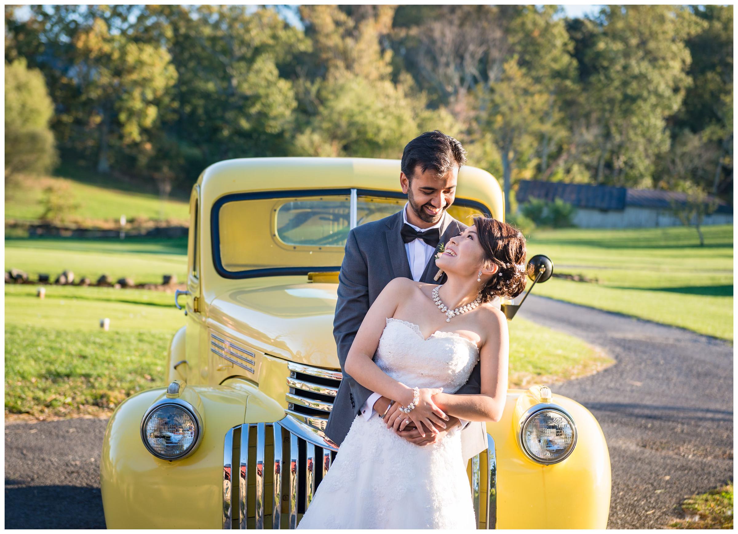 Bride and groom with vintage yellow truck during rustic wedding at Stoneleigh Golf Club
