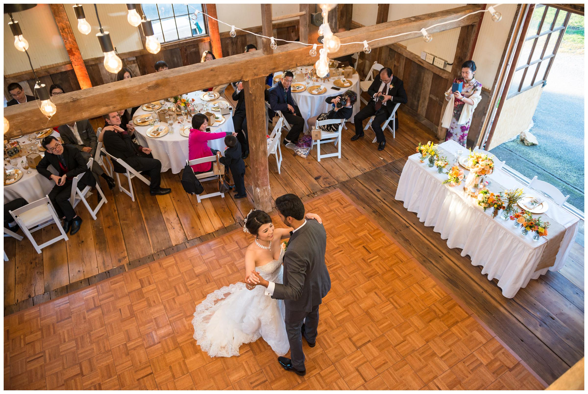 Bride and groom have their first dance during rustic barn reception.