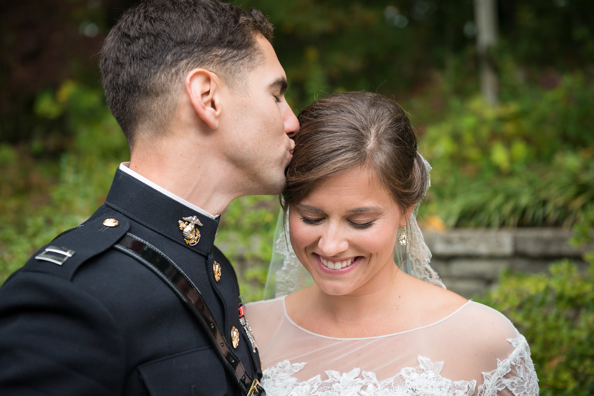 Marine groom kissing bride after military wedding