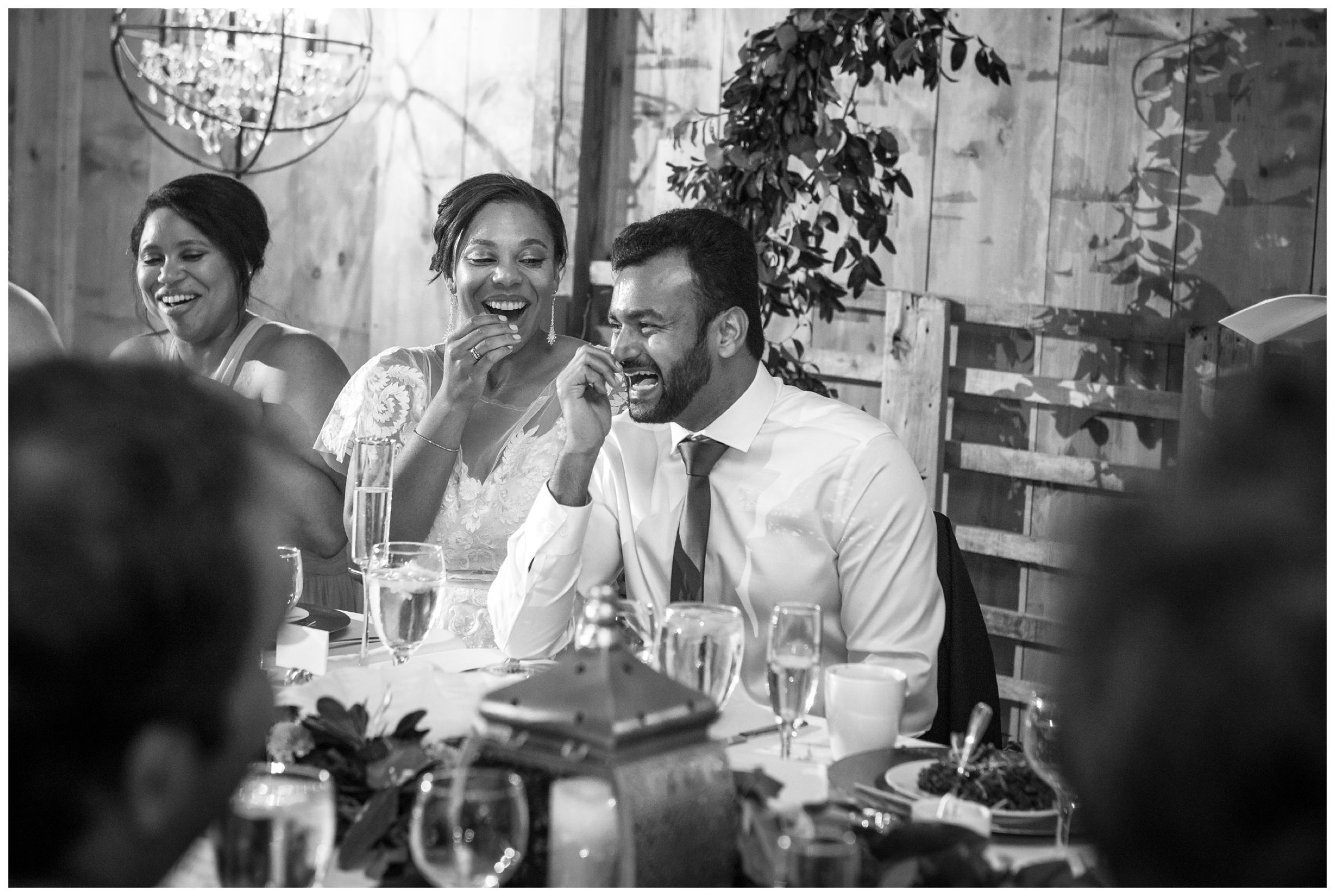 bride and groom laughing at wedding toast during barn wedding reception in Columbus