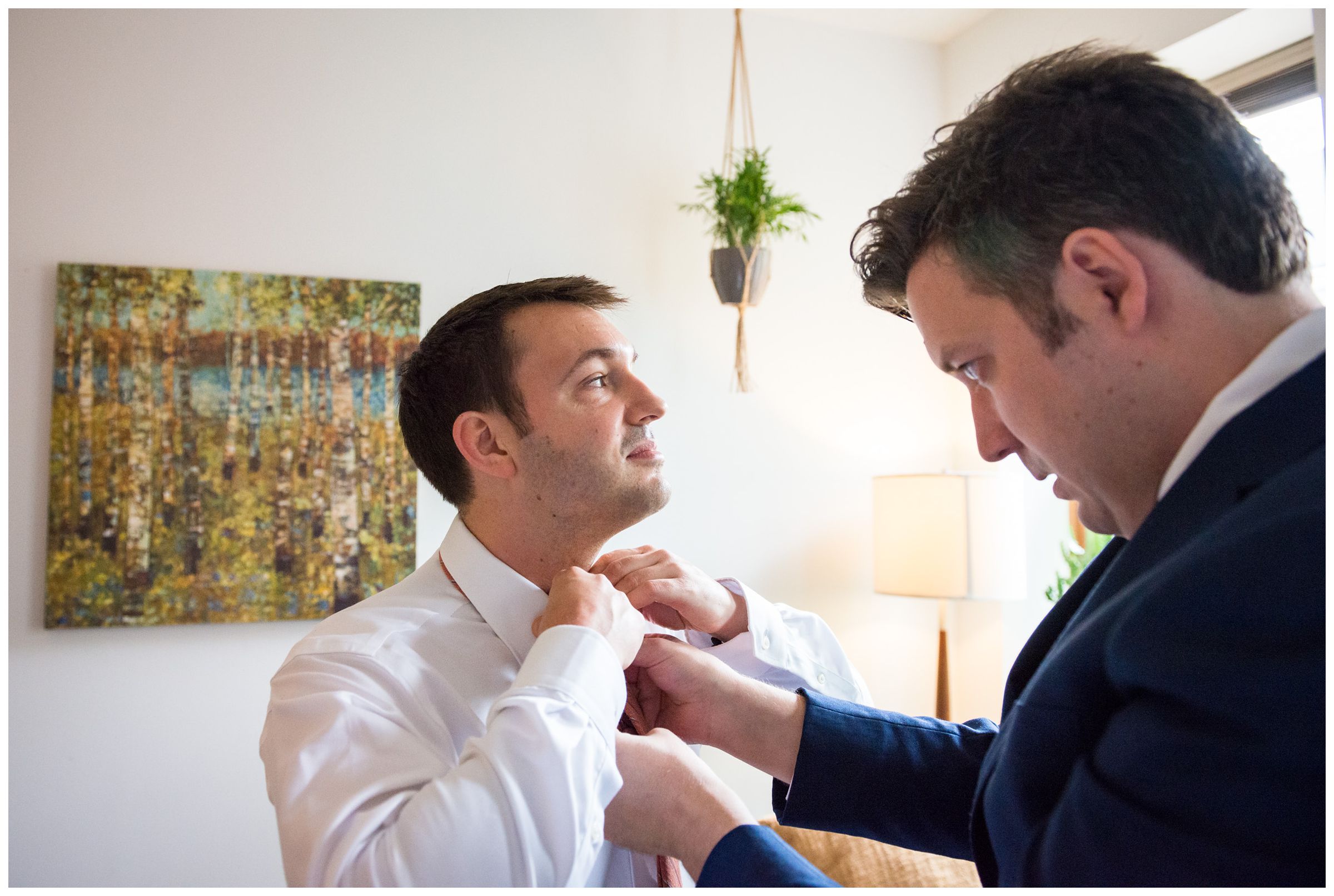 groomsman helps groom with tie before Short North Columbus wedding