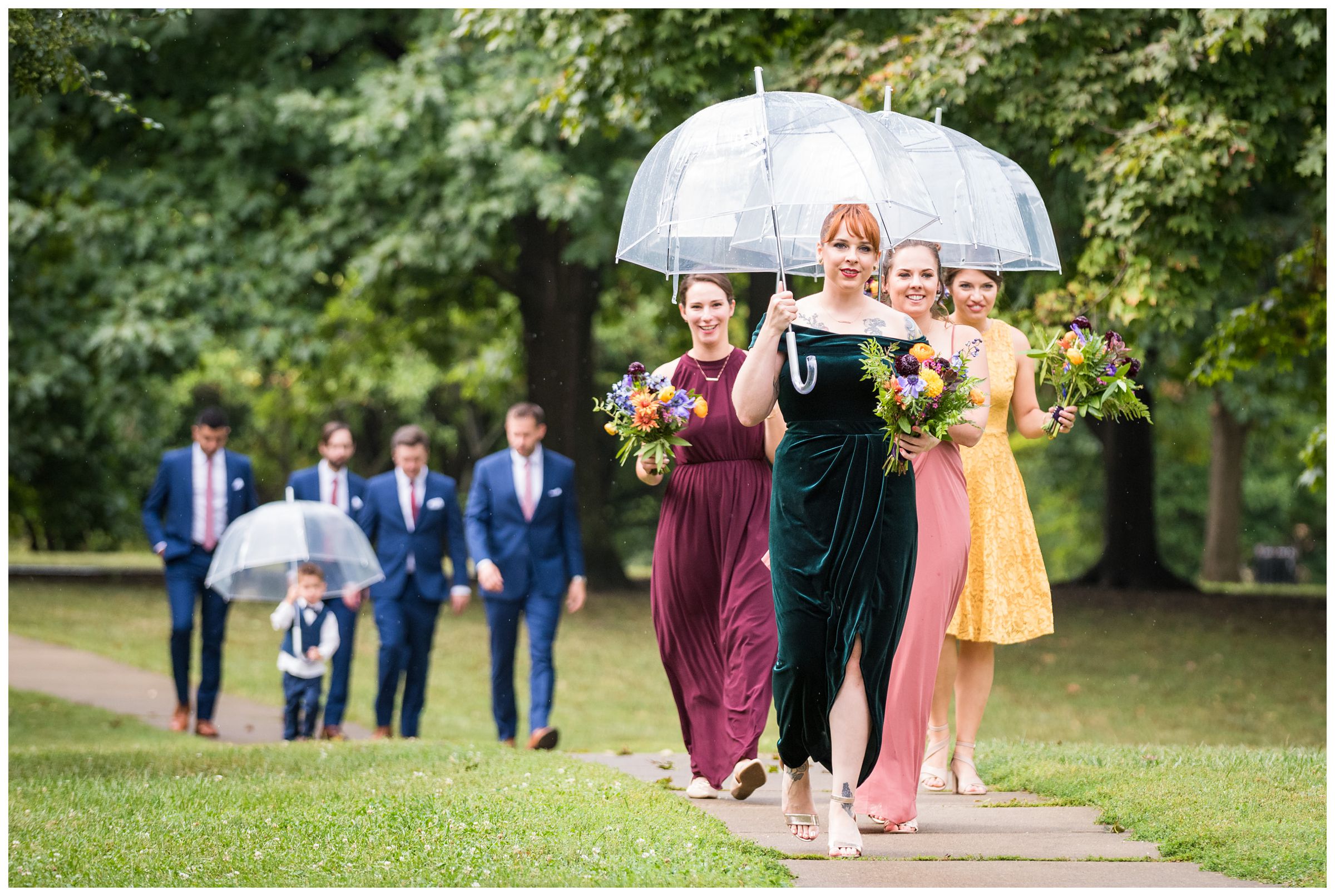 bridesmaids carrying umbrellas during a rainy wedding day in Goodale Park in Columbus