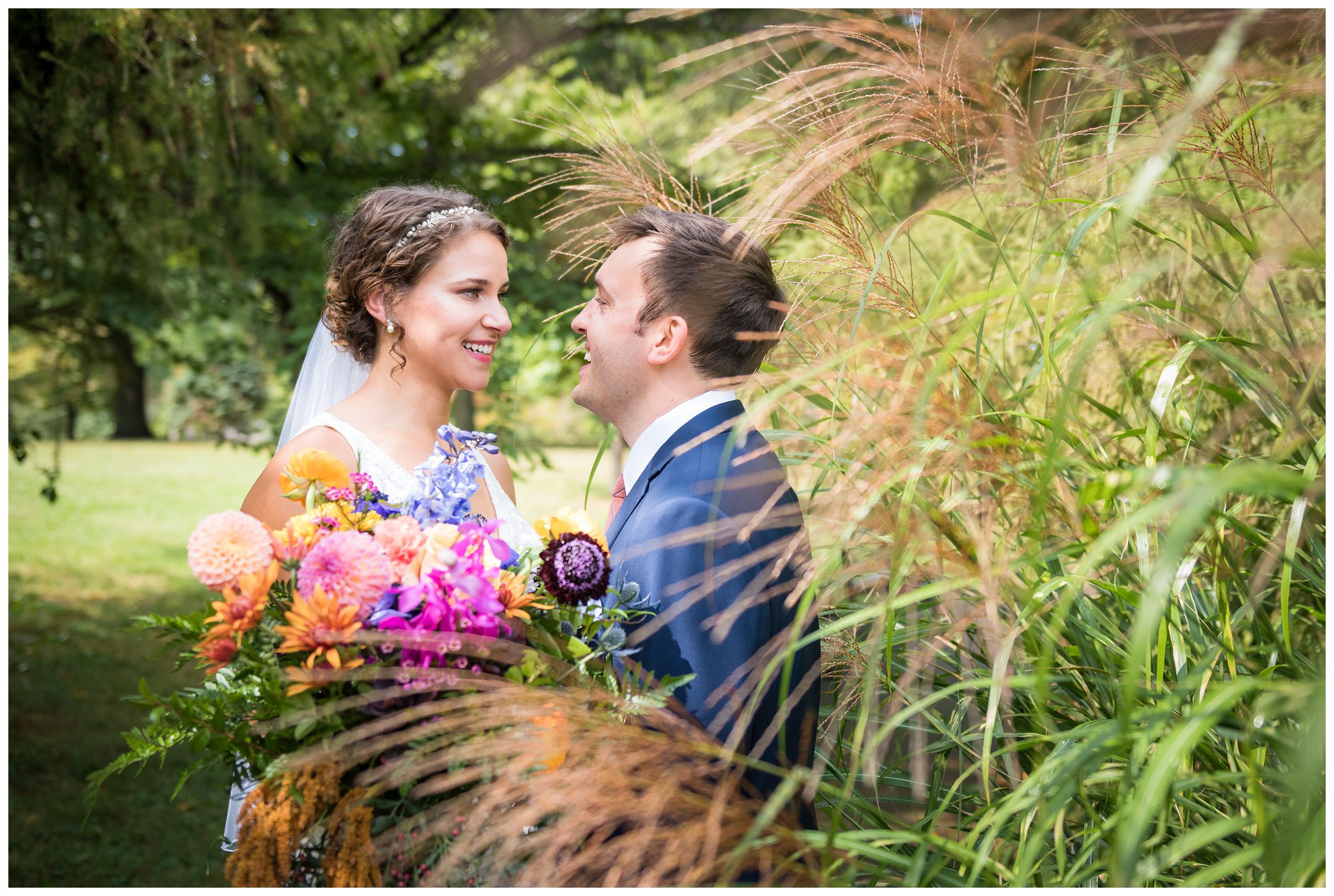bride and groom among the tall grass at Goodale Park during wedding photos in Columbus Ohio
