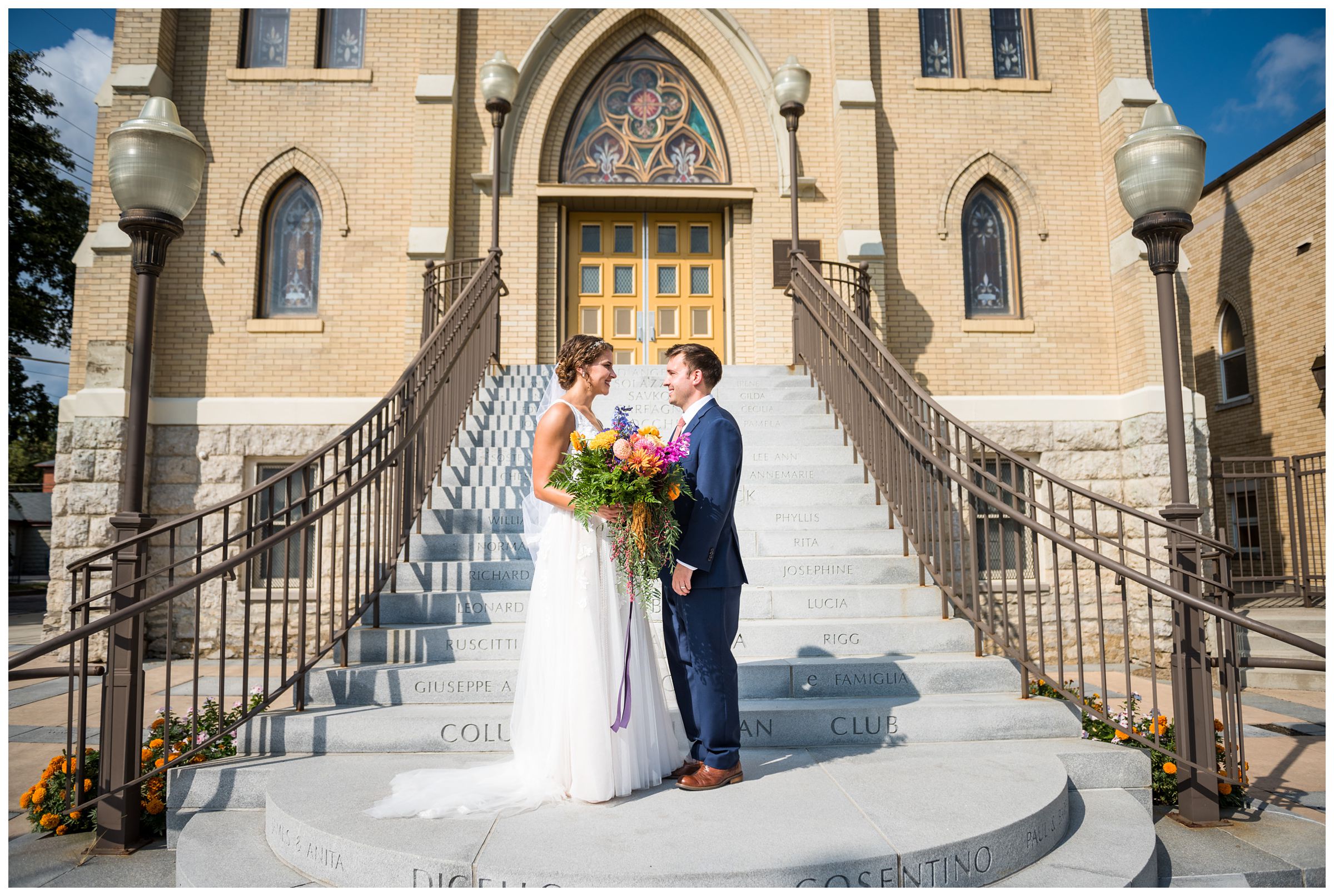 bride and groom obride and groom on stairs in front of St. John the Baptist Catholic Church in Italian Village of Columbus, Ohio