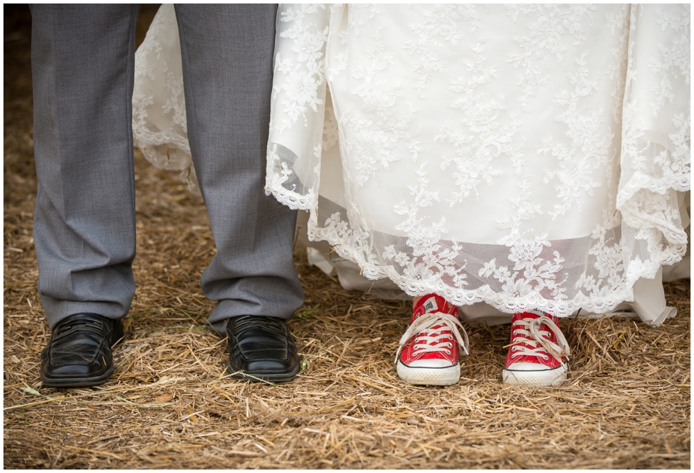 bride wearing Converse Chucks in rustic barn wedding