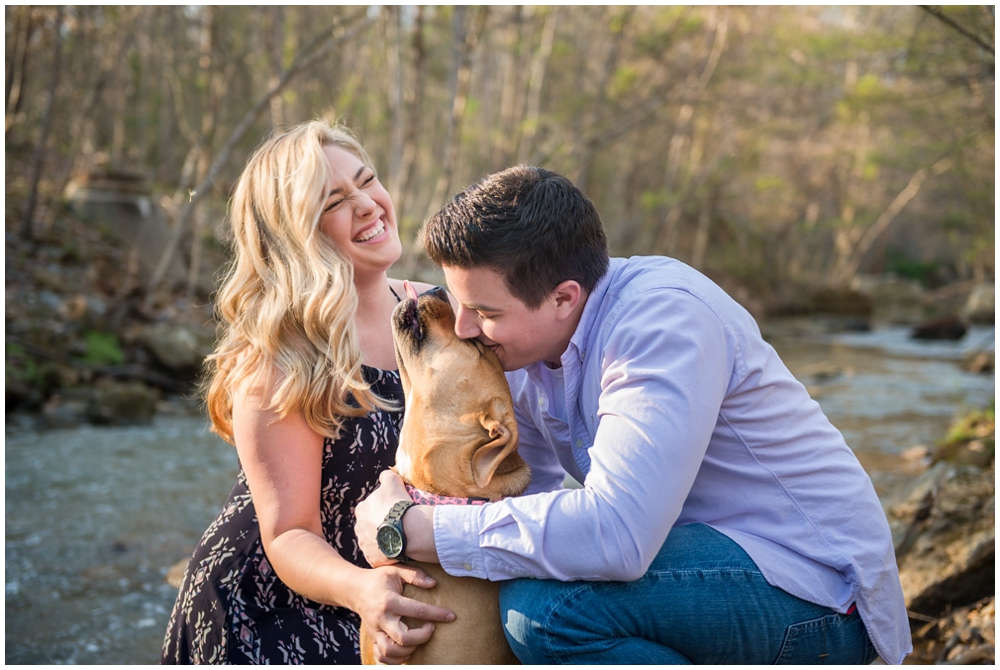 engaged couple with dog at park near stream