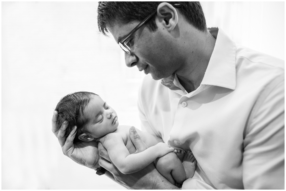 dad with newborn baby girl in home