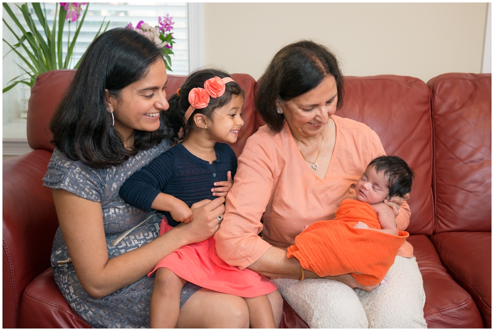 mom, grandma and sister with newborn baby girl in home