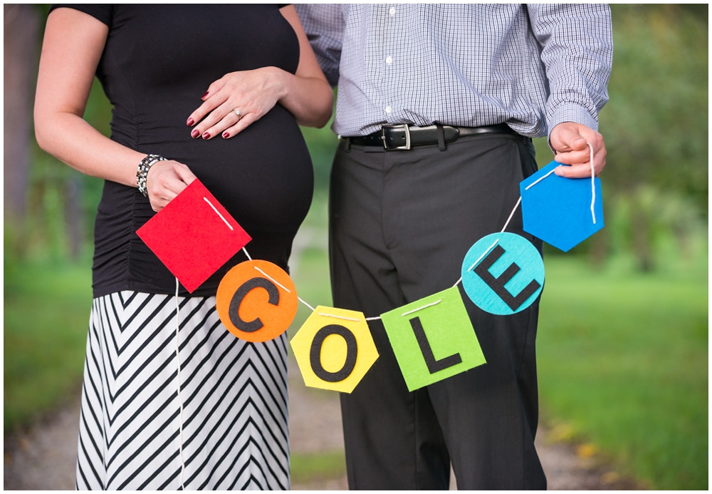 pregnant couple in park with banner