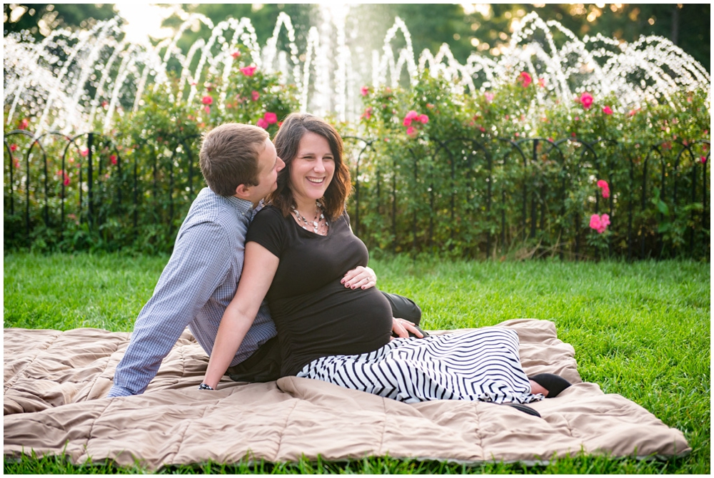 pregnant couple in park with fountain