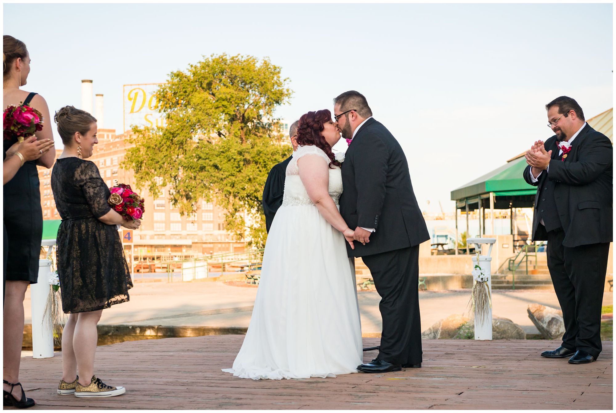 Bride and groom first kiss during harbor wedding at Baltimore Museum of Industry