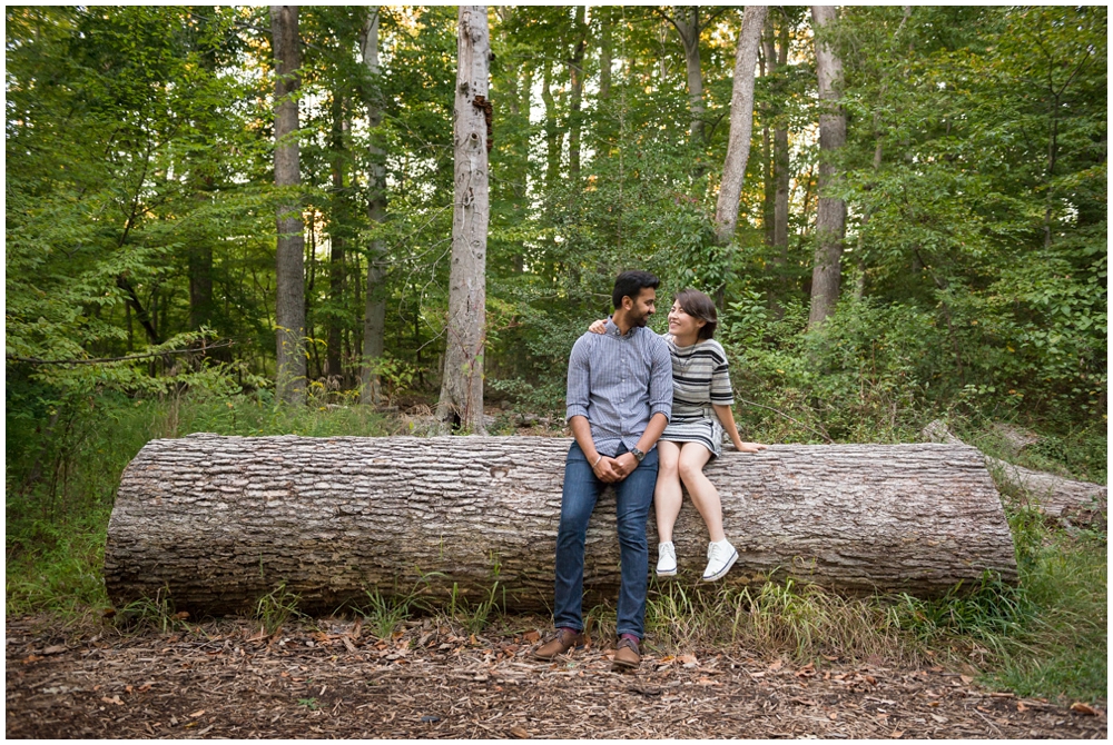 Engaged couple on large log at Green Spring Gardens in Alexandria, Virginia