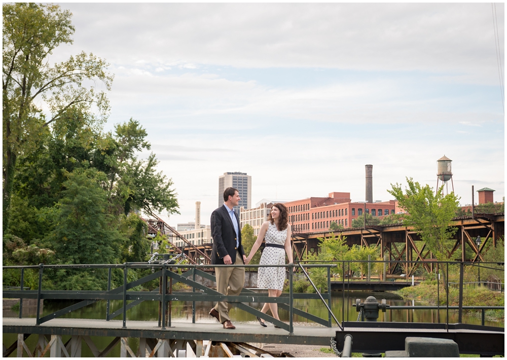 engaged couple walking across bridge