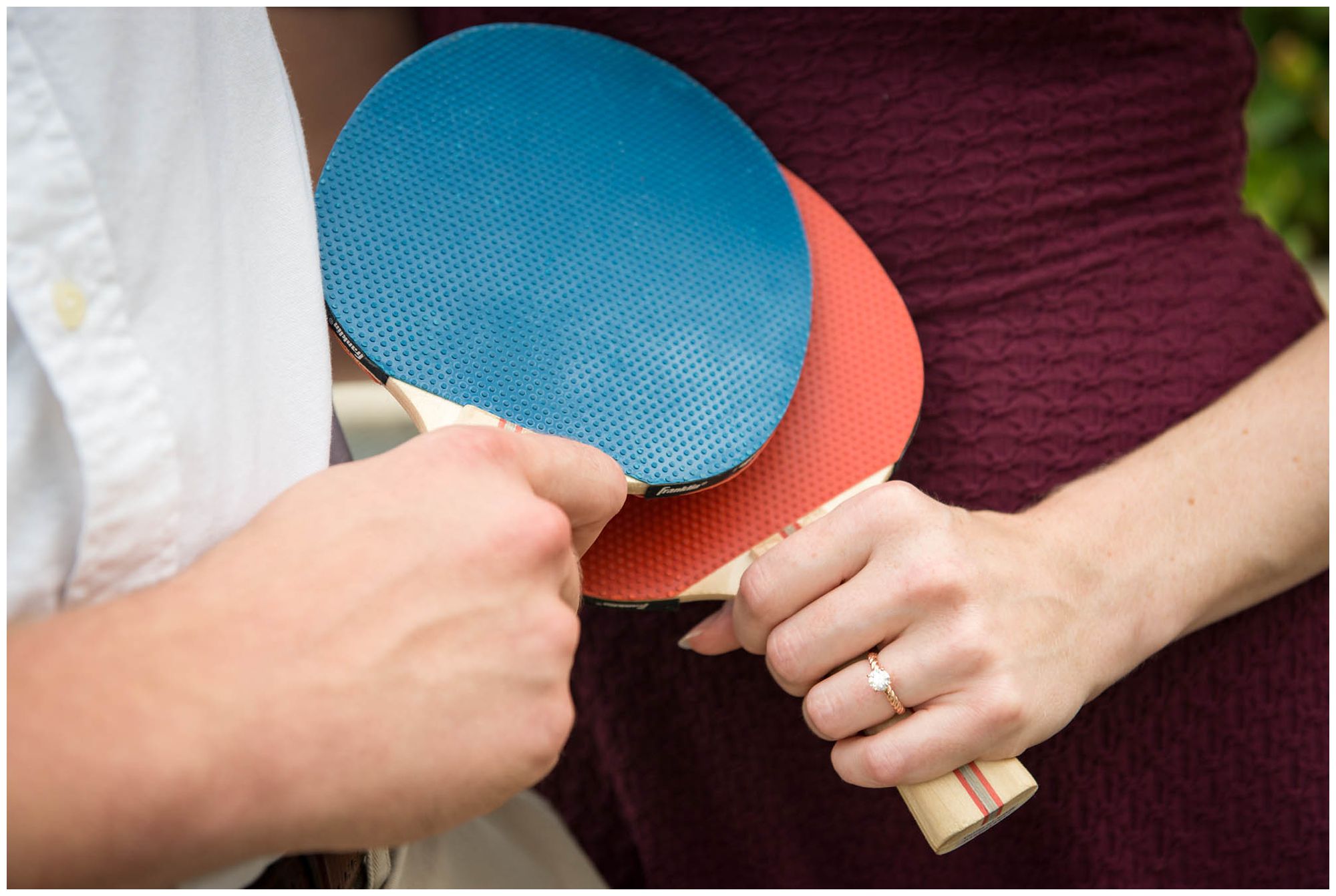 engaged couple playing ping pong in urban park