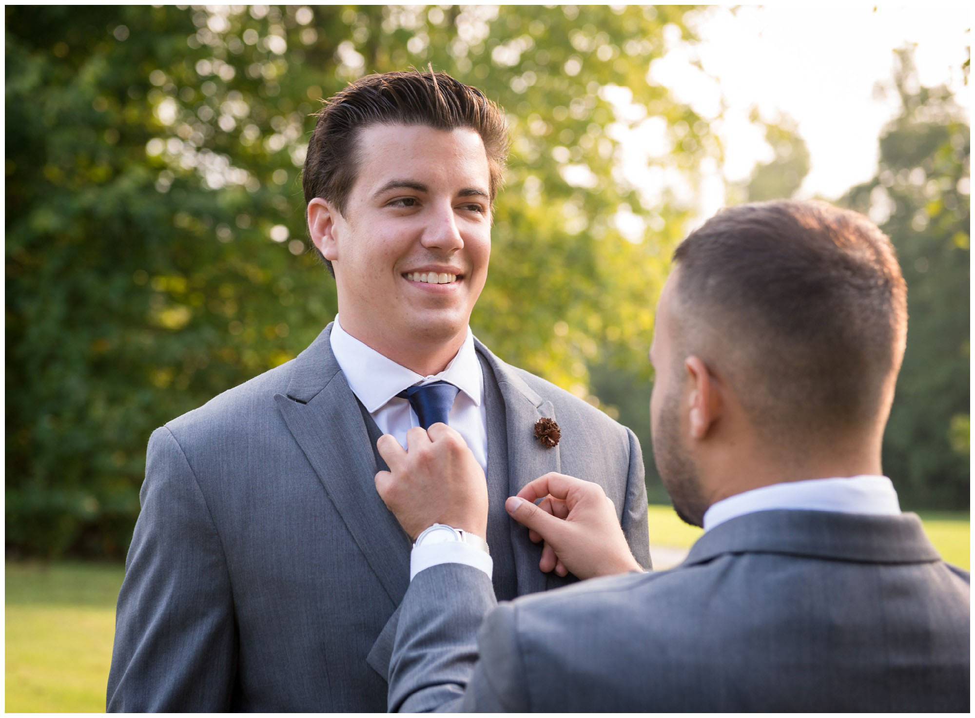 groom tying tie before wedding