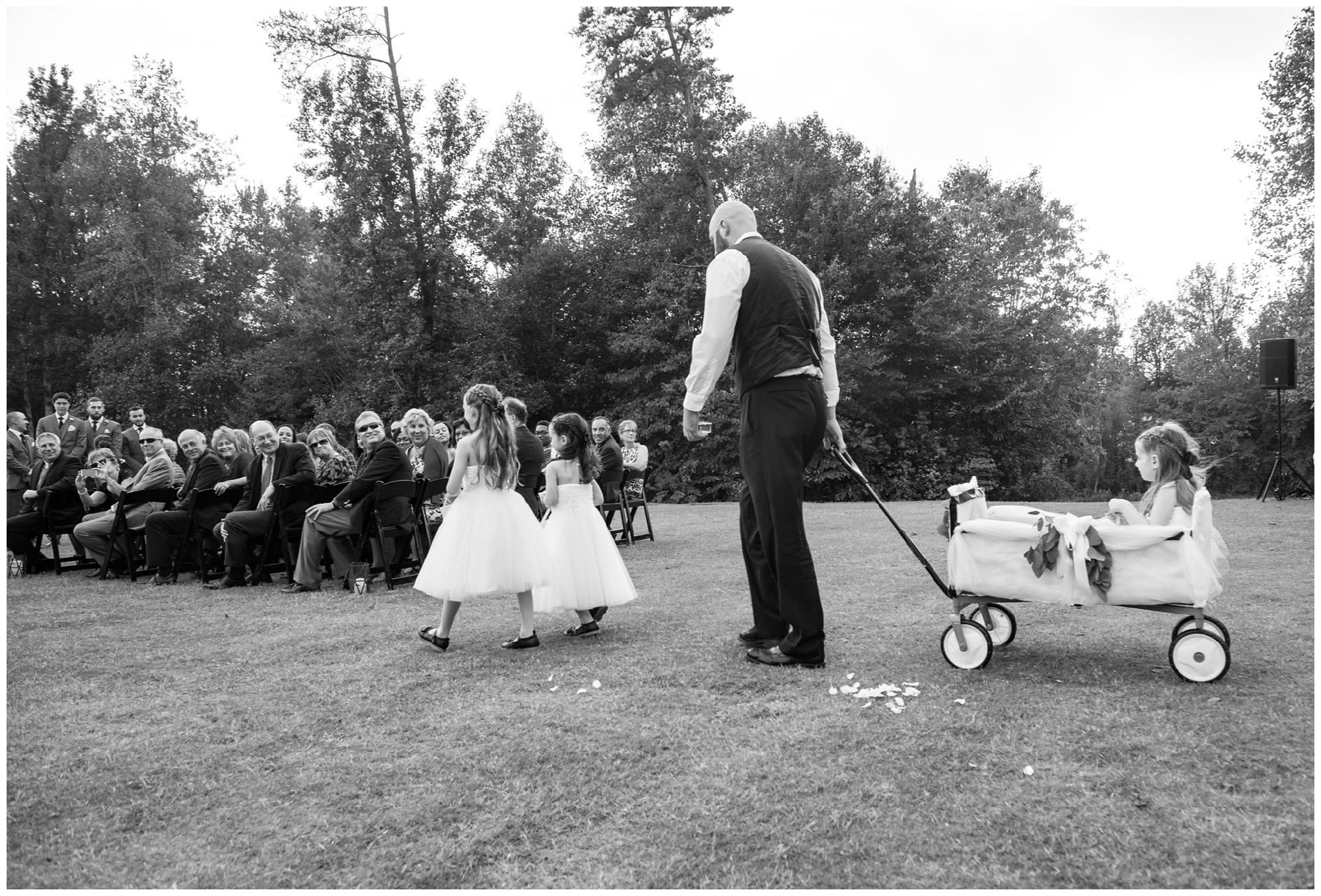 flower girls entering wedding ceremony in wagon