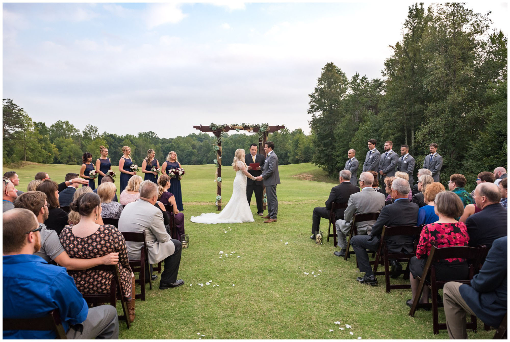 bride and groom holding hands during wedding ceremony on golf course