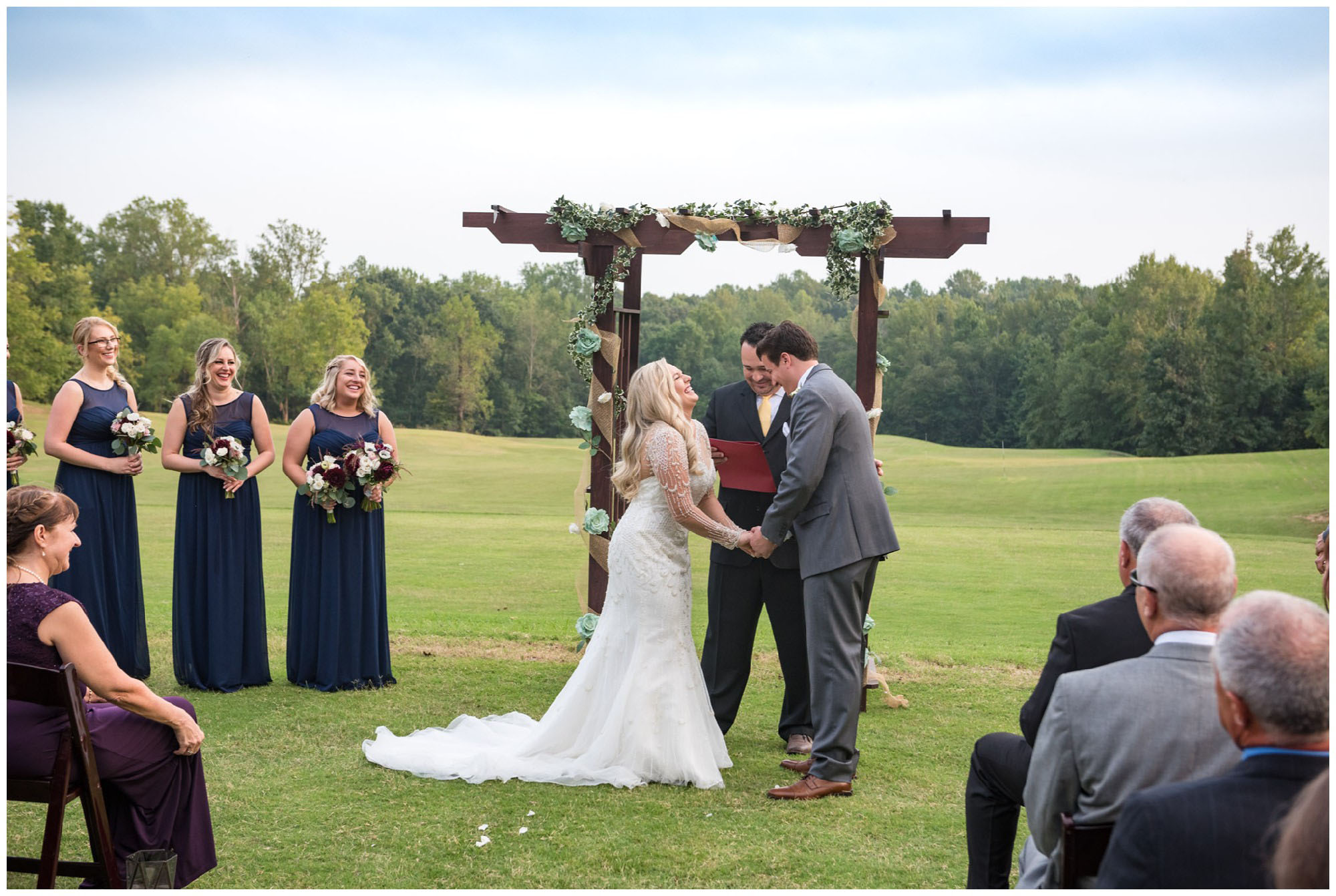 bride and groom laughing during wedding ceremony on golf course