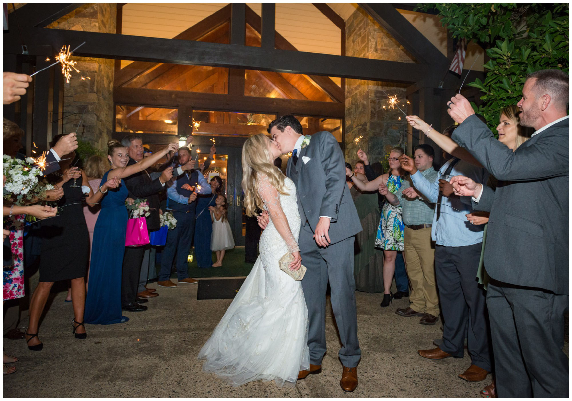 bride and groom kissing during sparkler send off