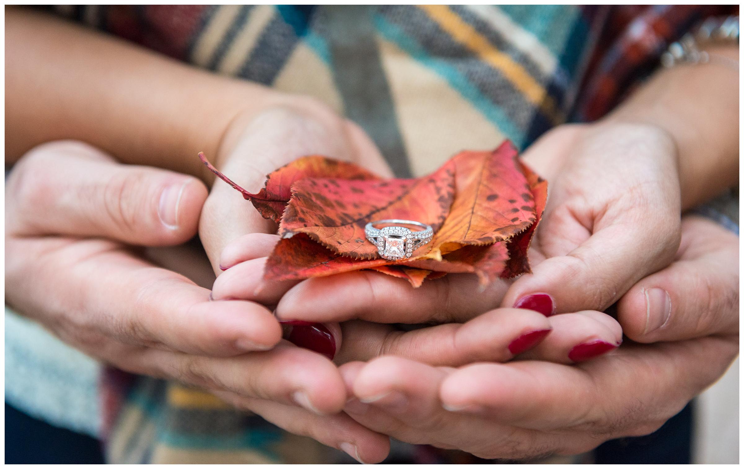 engagement ring closeup with red fall leaves