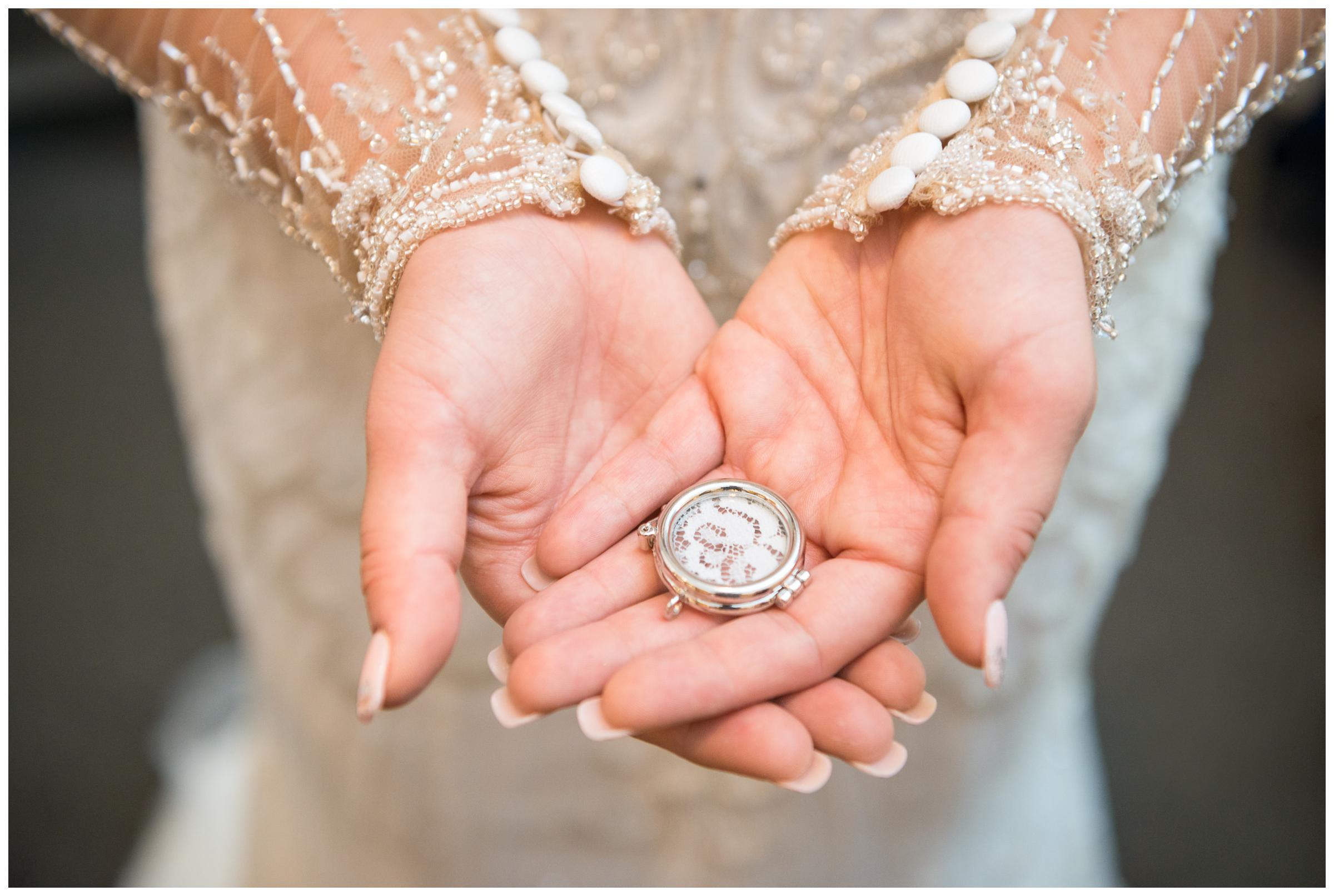 bride holding locket of mother's lace