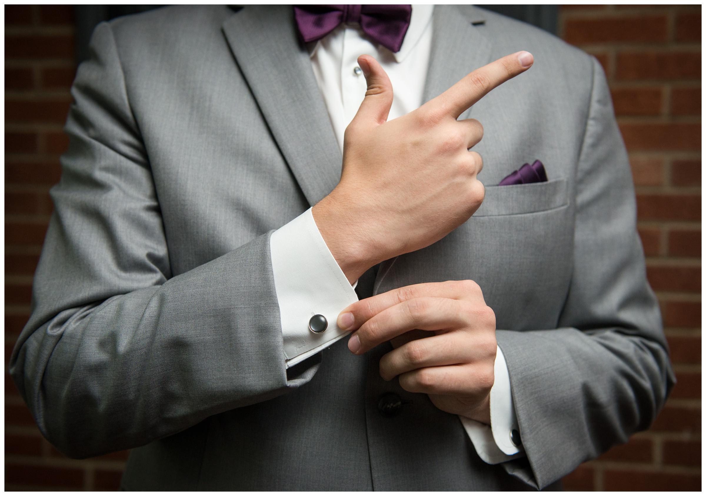 detail of groom's cufflinks while he makes James Bond gesture