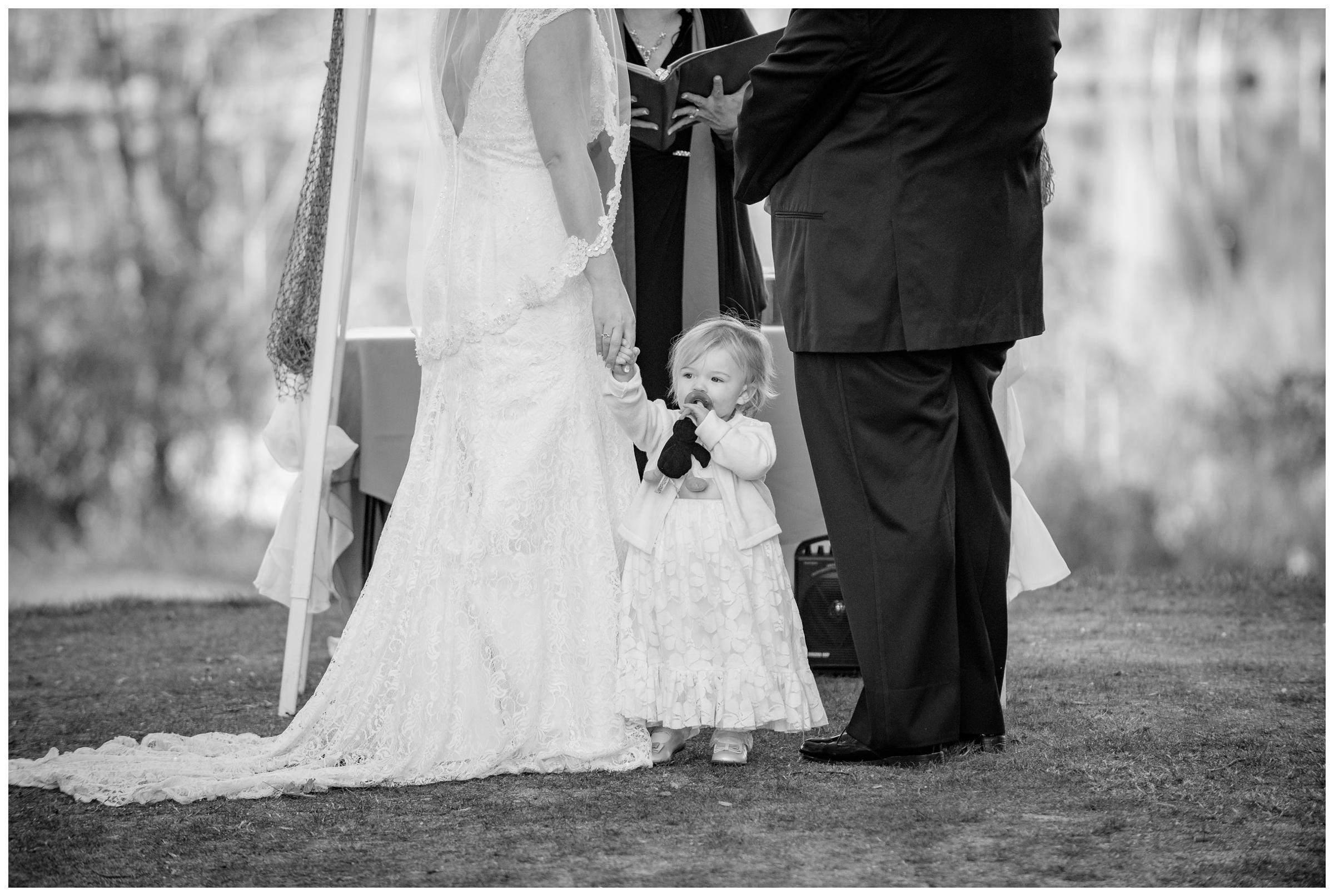 bride and groom's daughter standing with them during wedding ceremony