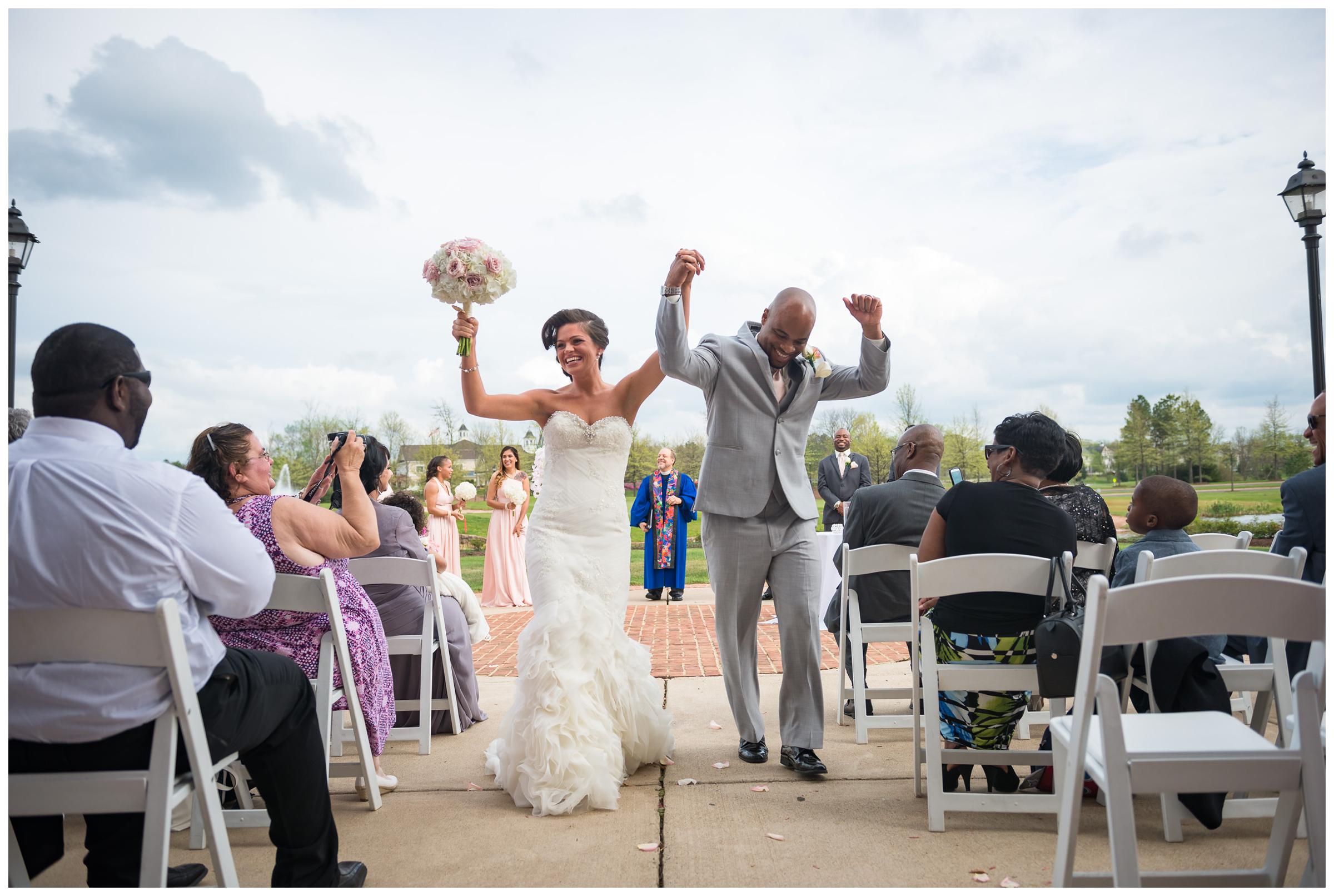 bride and groom cheering during wedding recessional