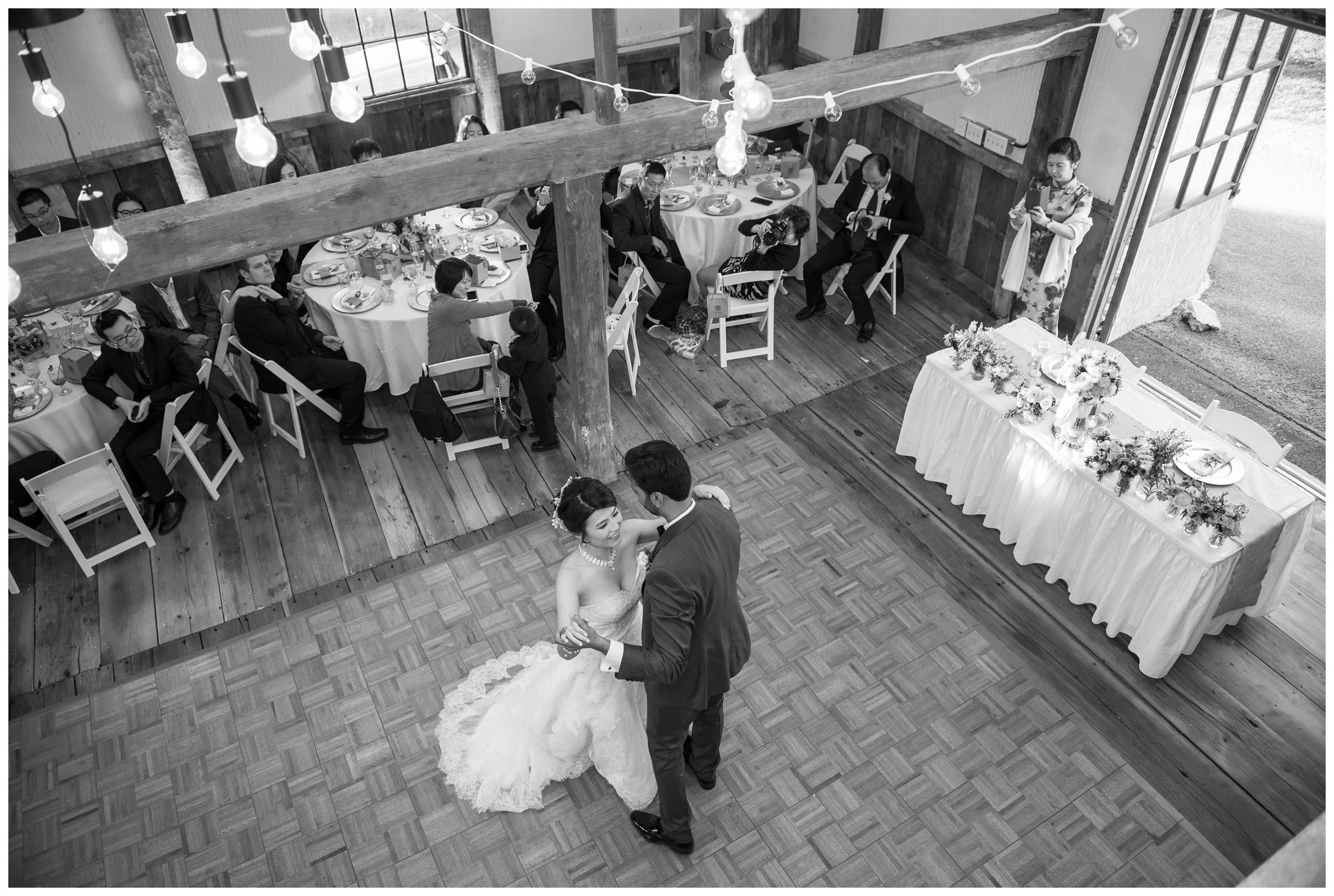 bride and groom share first dance in barn reception