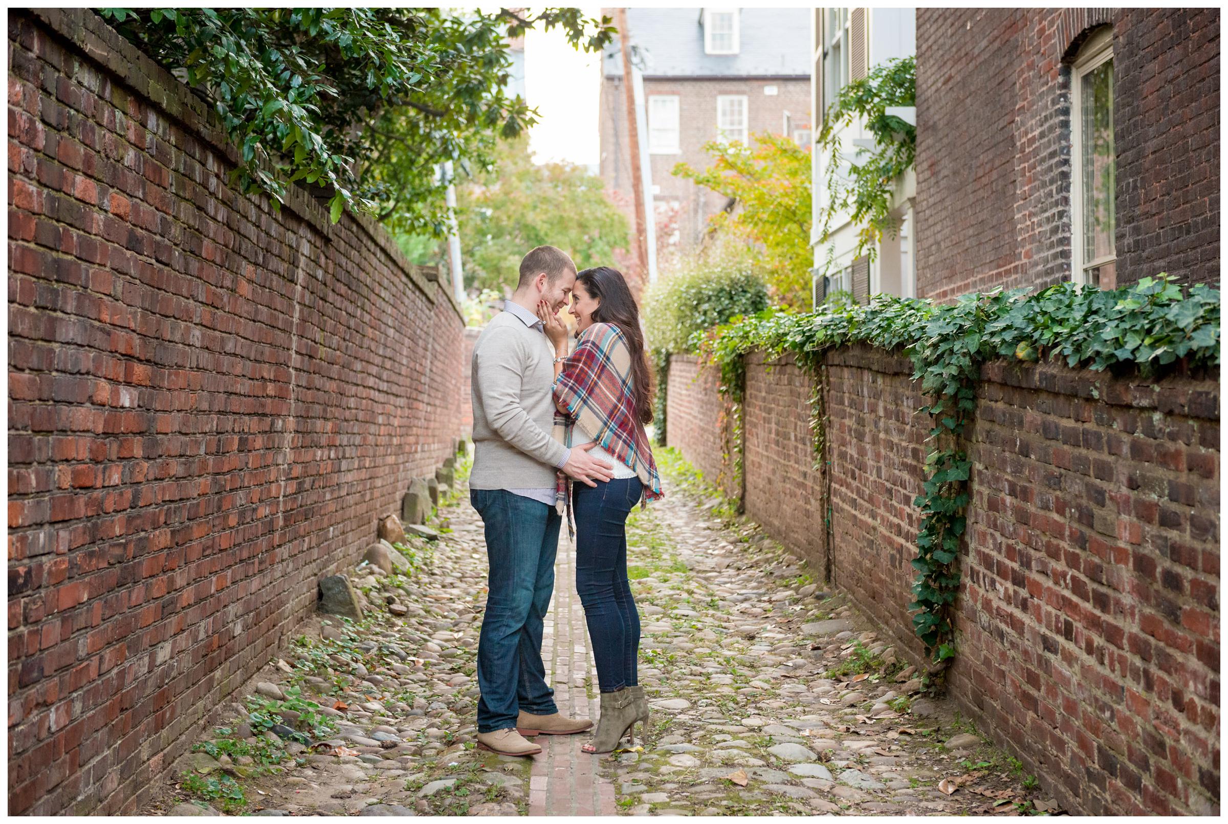 engaged couple in cobblestone alleyway in Old Town Alexandria, Virginia.