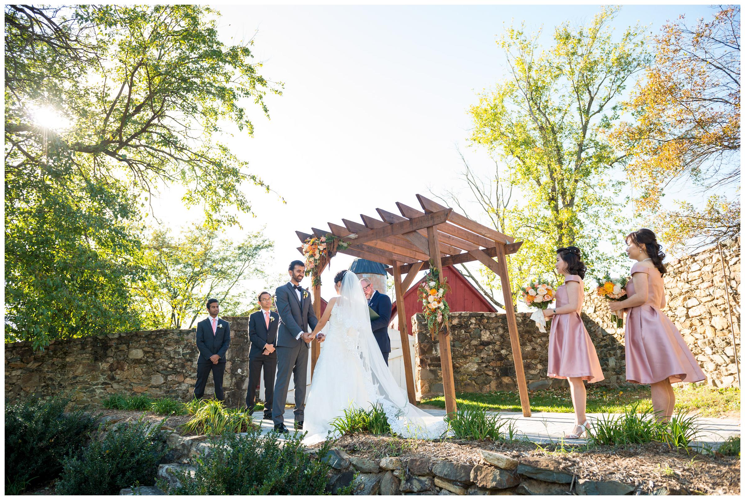 Bride and groom with bridal party during rustic fall wedding ceremony at Stoneleigh Golf Club in Virginia