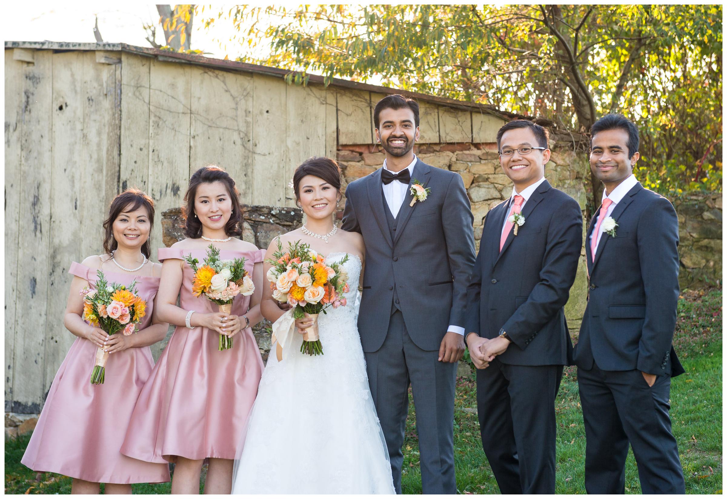 Portrait of bridal party near stone ruins at rustic wedding.