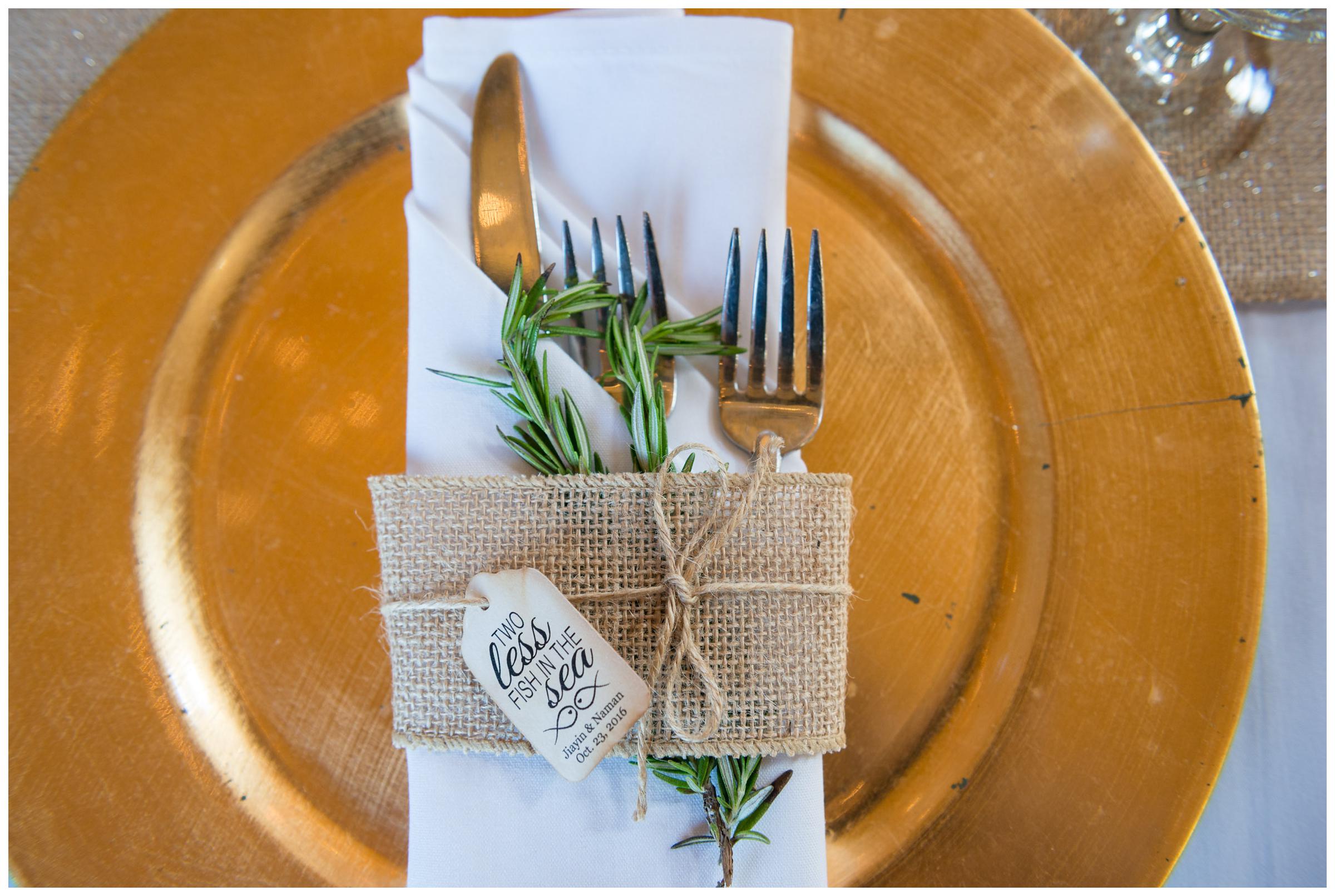 Rustic gold and burlap reception place settings with herbs.