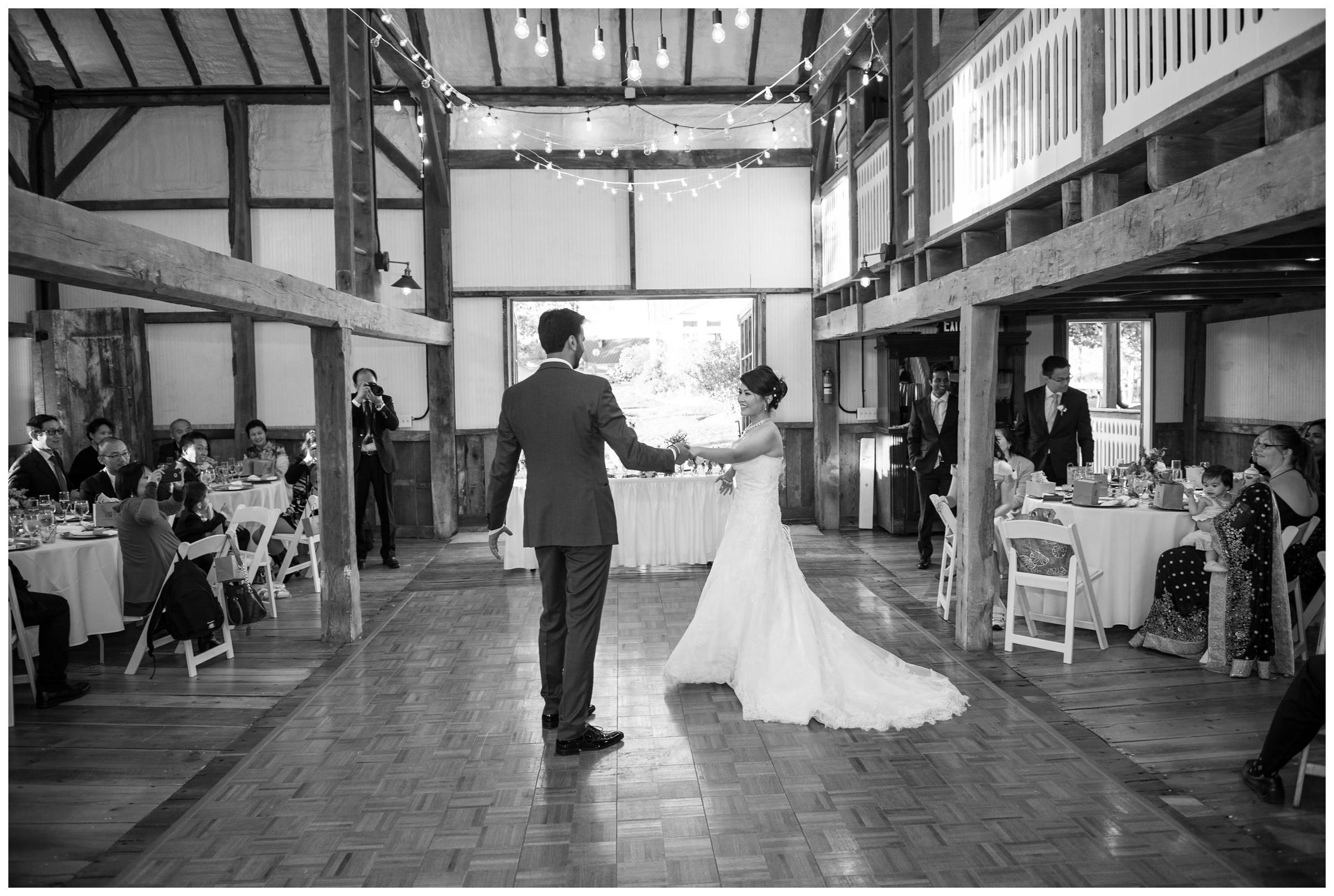 Bride and groom have their first dance during rustic barn reception at Stoneleigh Golf Club in Round Hill, Virginia.