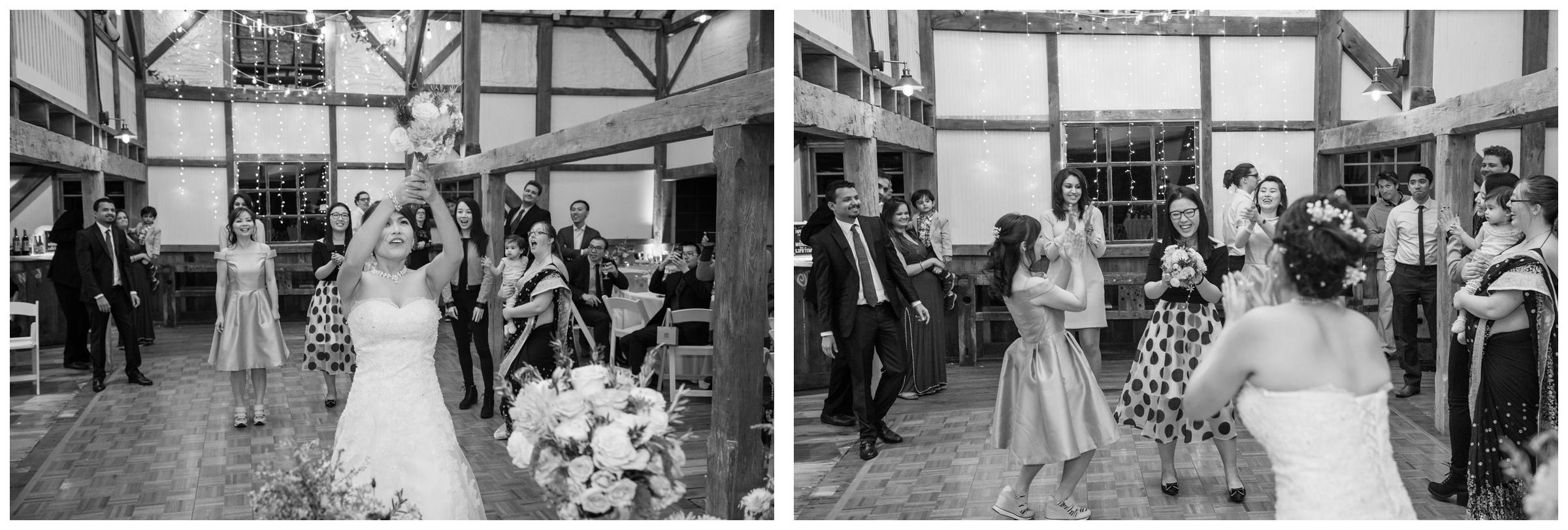 Bride tosses her bouquet during rustic wedding in barn.