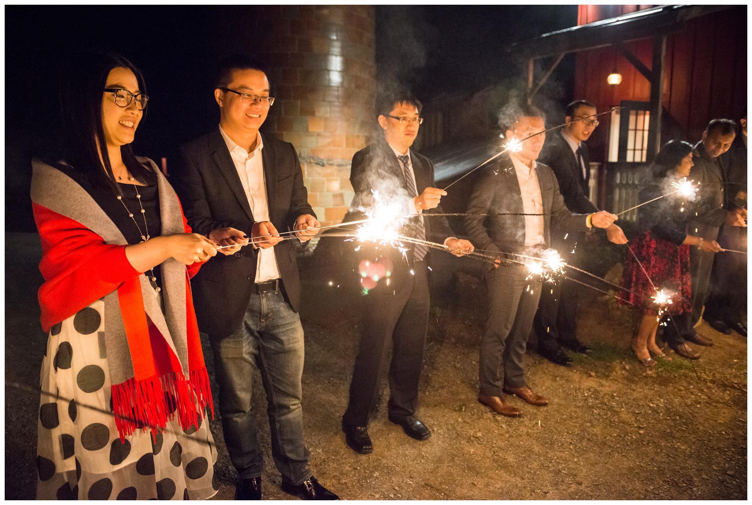 guests light sparklers for wedding send-off