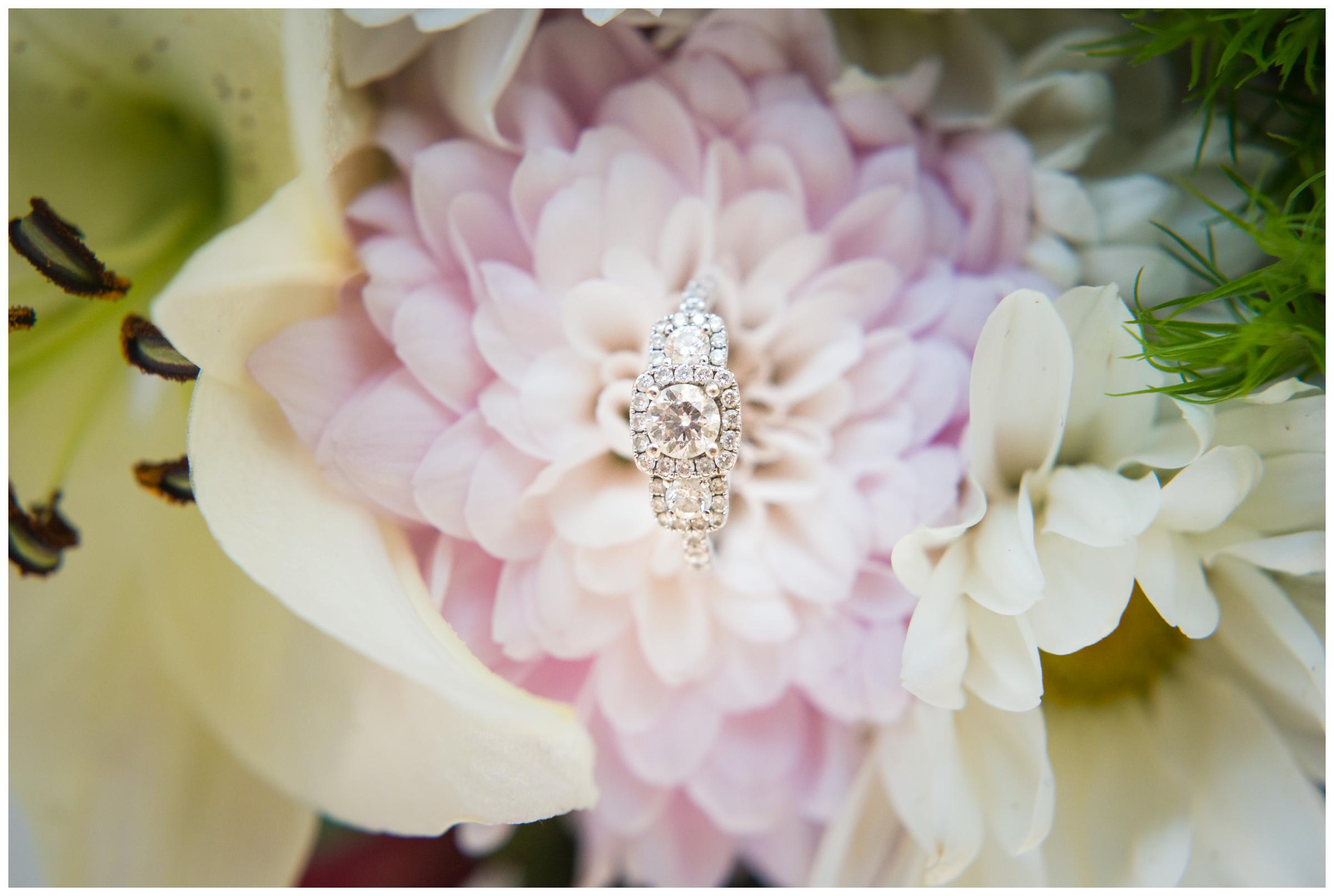 engagement ring sitting on pink flower