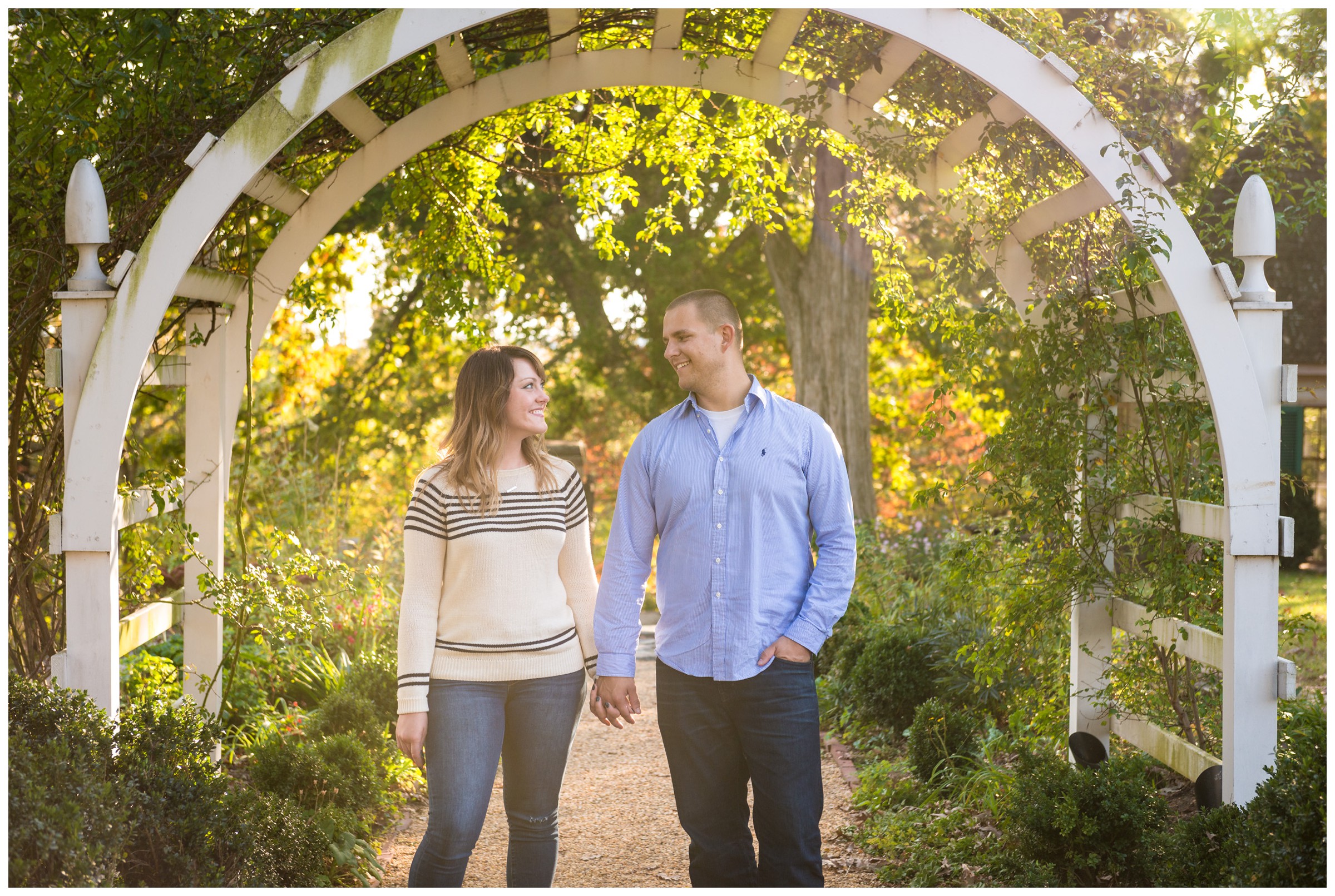 engaged couple under archway with fall foliage at Belmont in Fredericksburg, Virginia