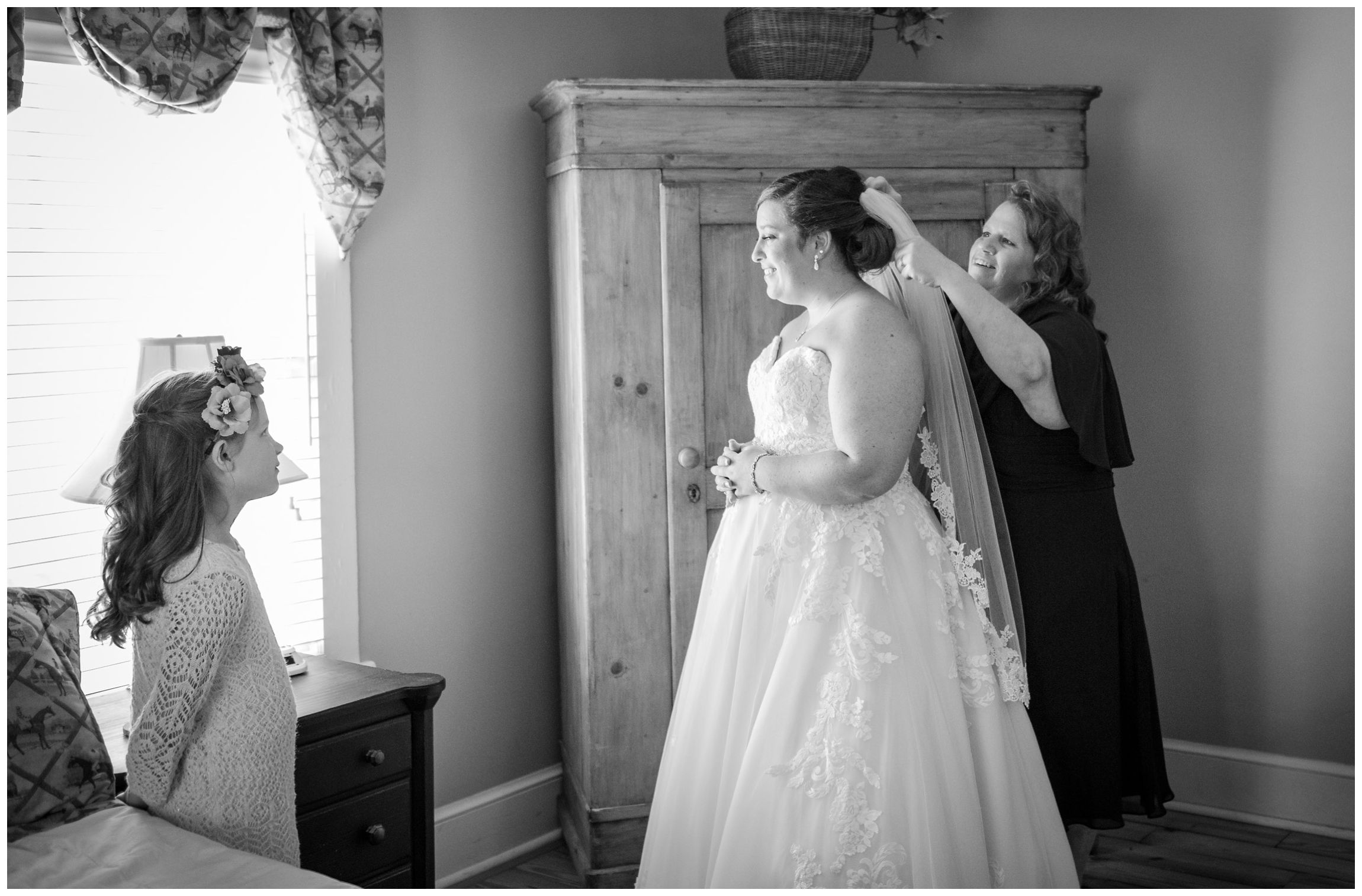 bride's mom putting on her veil while flower girl watches