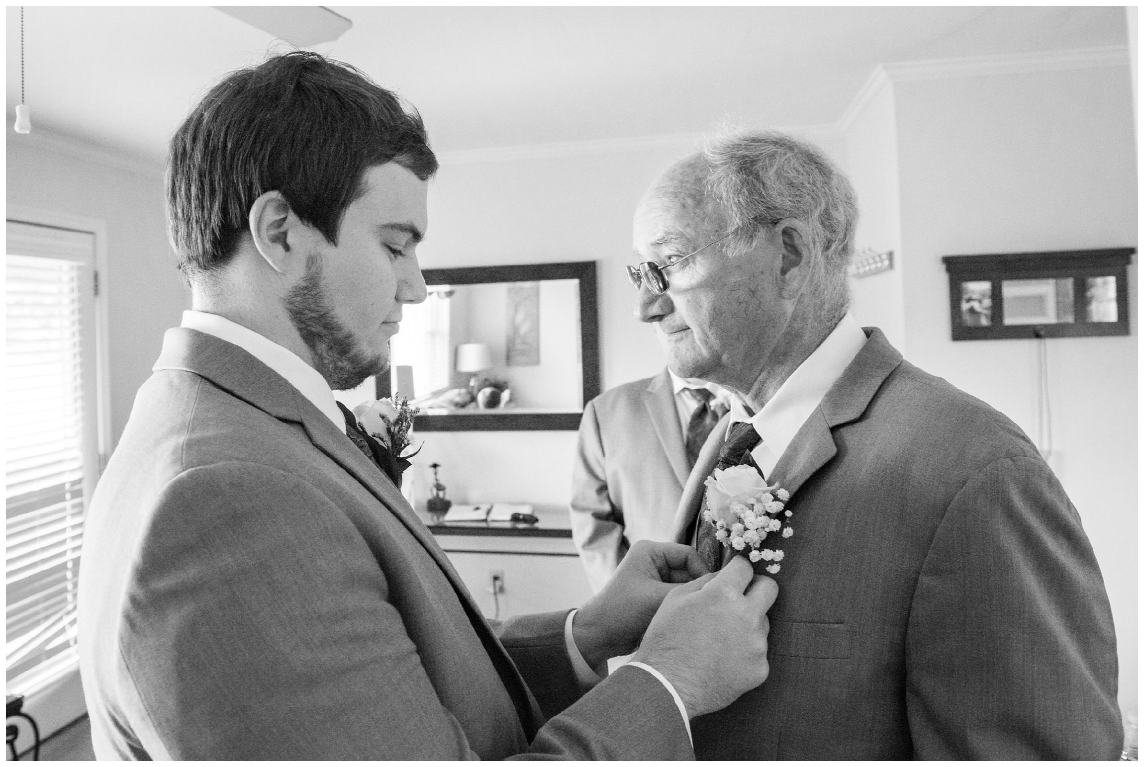 groom pins boutonniere on his dad and best man
