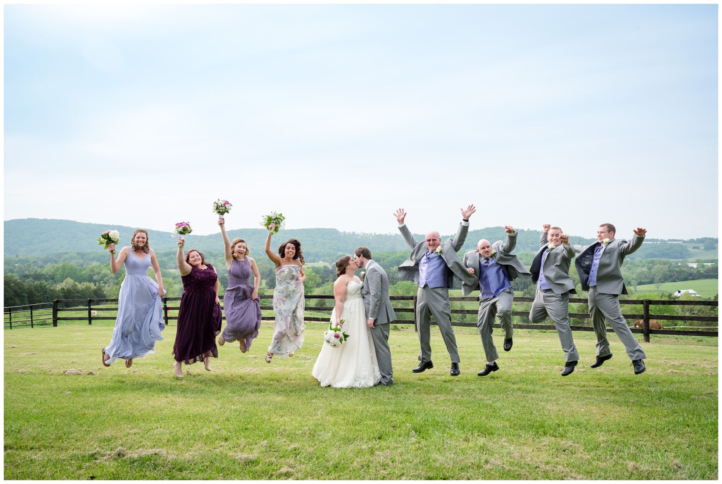 bridal party jumping against mountain backdrop after wedding at Wolftrap Farm in Virginia