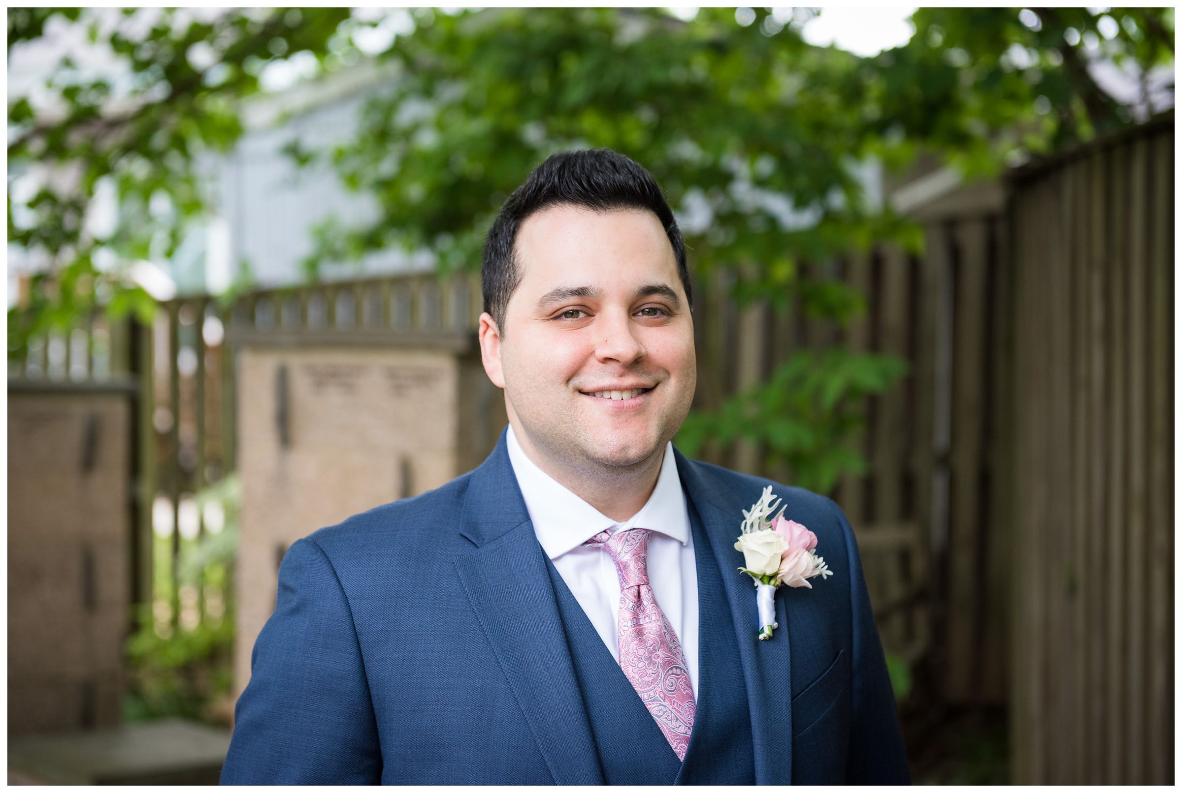 groom wearing navy Tommy Hilfiger suit with blush pink tie