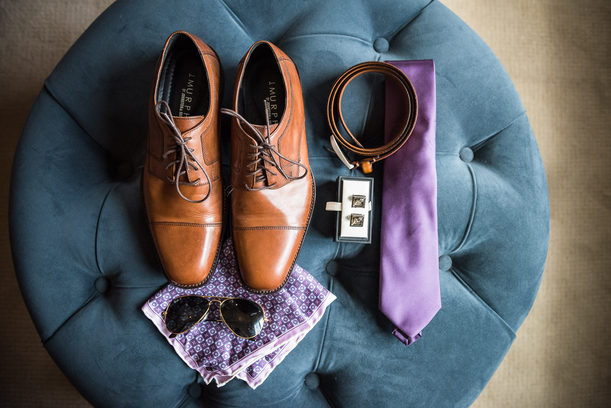 groom's purple wedding day attire, including brown shoes, belt, tie, cufflinks, handkerchief, and Ray Ban sunglasses