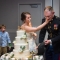 bride smashing cake into groom's face after Marine military sword cake cutting