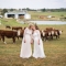 two brides kissing on farm with cows by LGBTQ friendly columbus wedding photographer