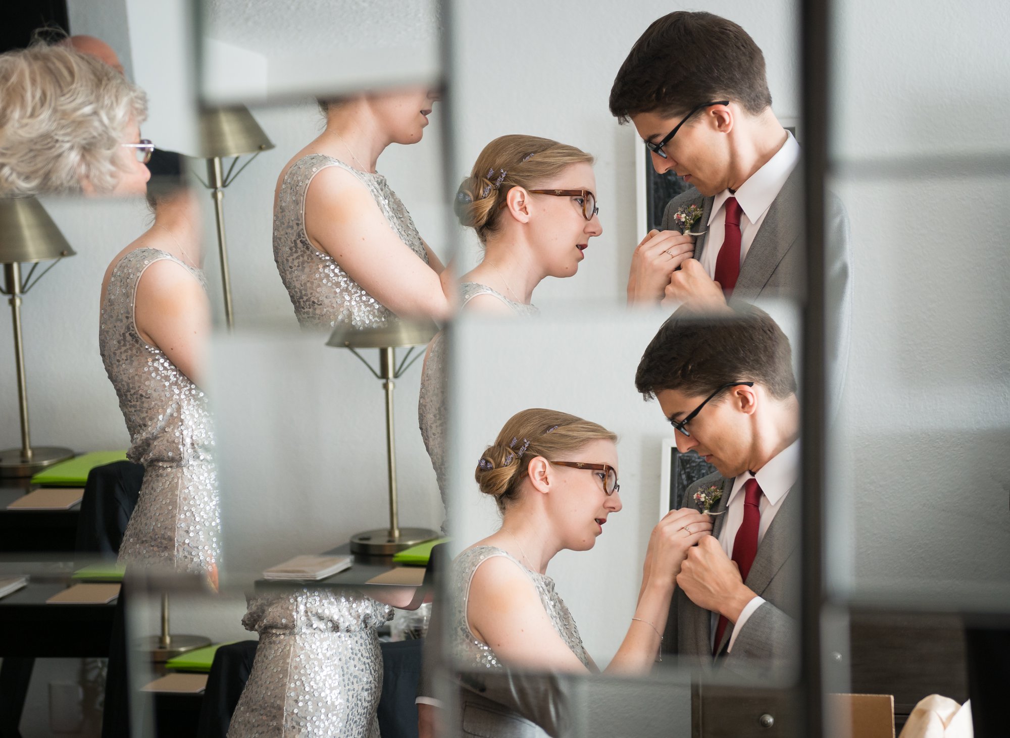couple getting ready for wedding reflected in mirror