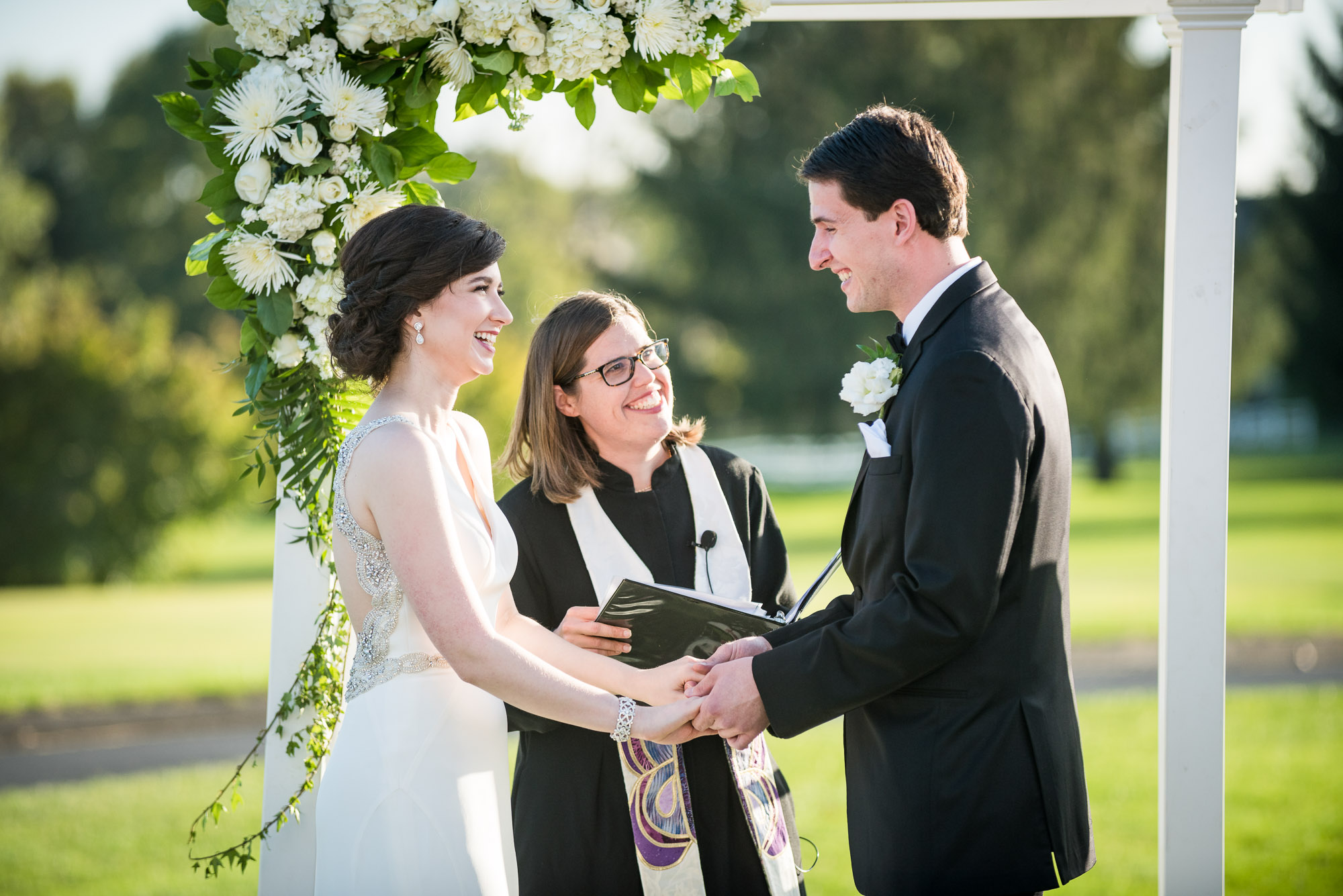 bride and groom laughing during wedding ceremony on golf course in Columbus Ohio
