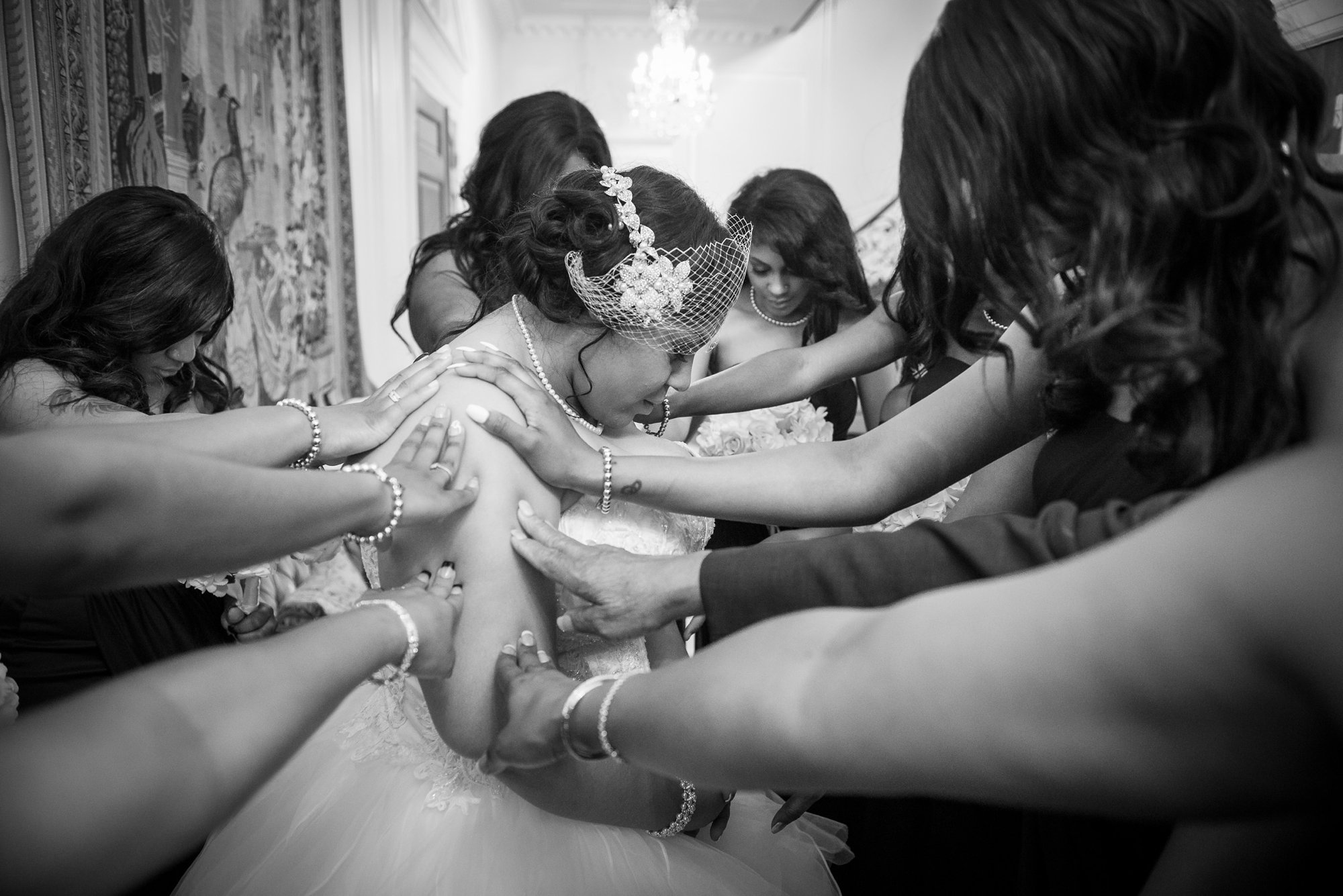bridesmaids praying with bride before wedding by Columbus wedding photojournalist