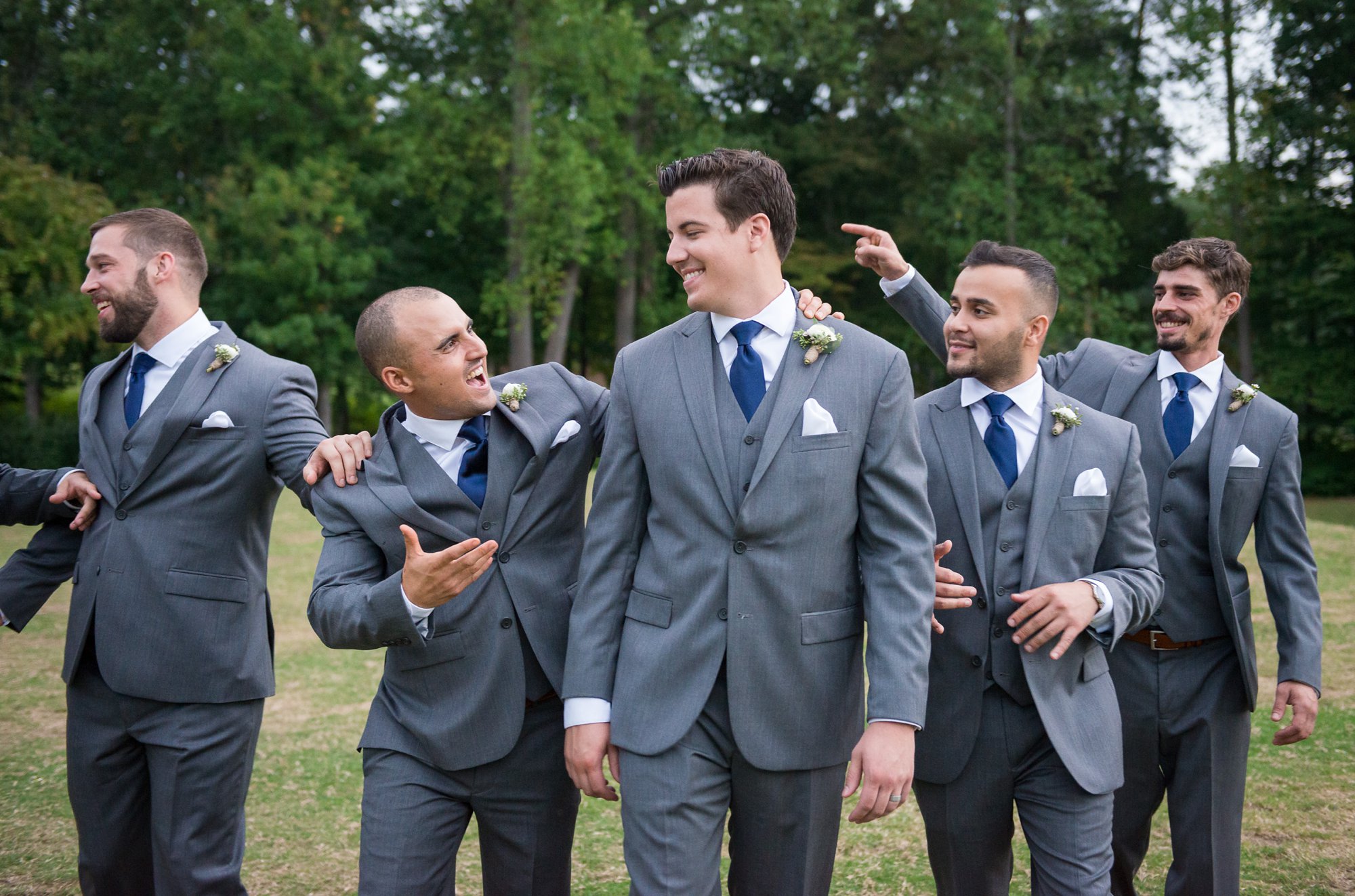 groom laughing with groomsmen on wedding day